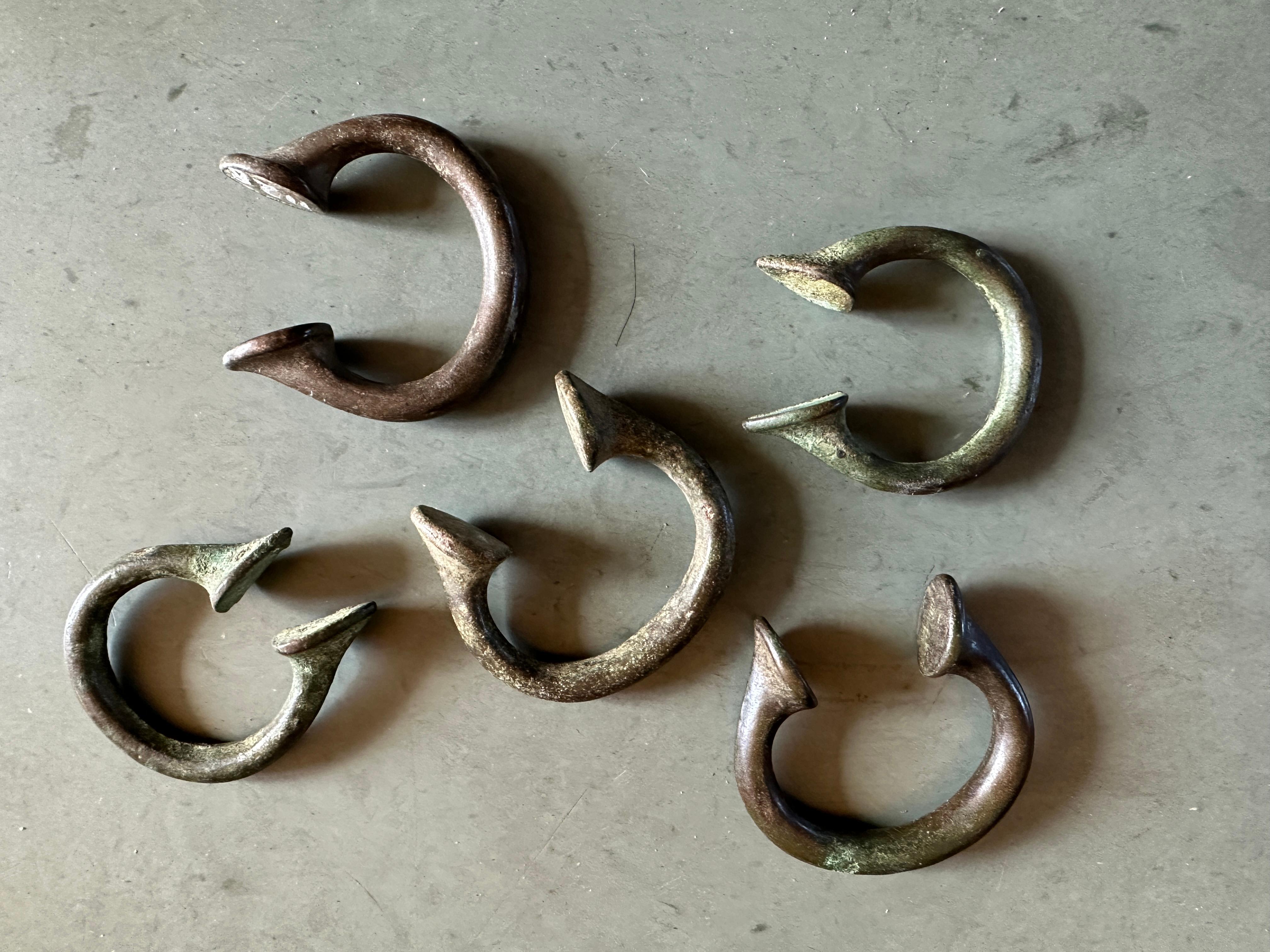 Manillas are horse-shoe shaped, made of an open circle of bronze, brass, or copper with enlarged finial terminations. They were used as a currency in West African countries from the 15th up to the late 20th century. Manillas were brought to West