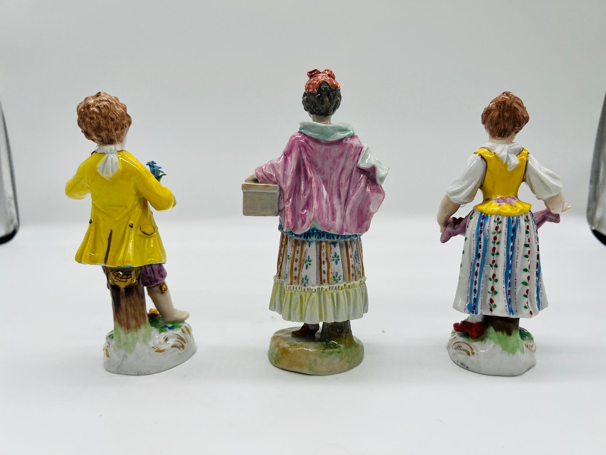Dresden Porcelain (German, 1872-2020), circa post 1902.

A grouping of 3 antique porcelain figures including:
1) Young Boy Picking Flowers
2) Young Girl Collecting Flowers 
3) Lady With Basket

Sold as a collection