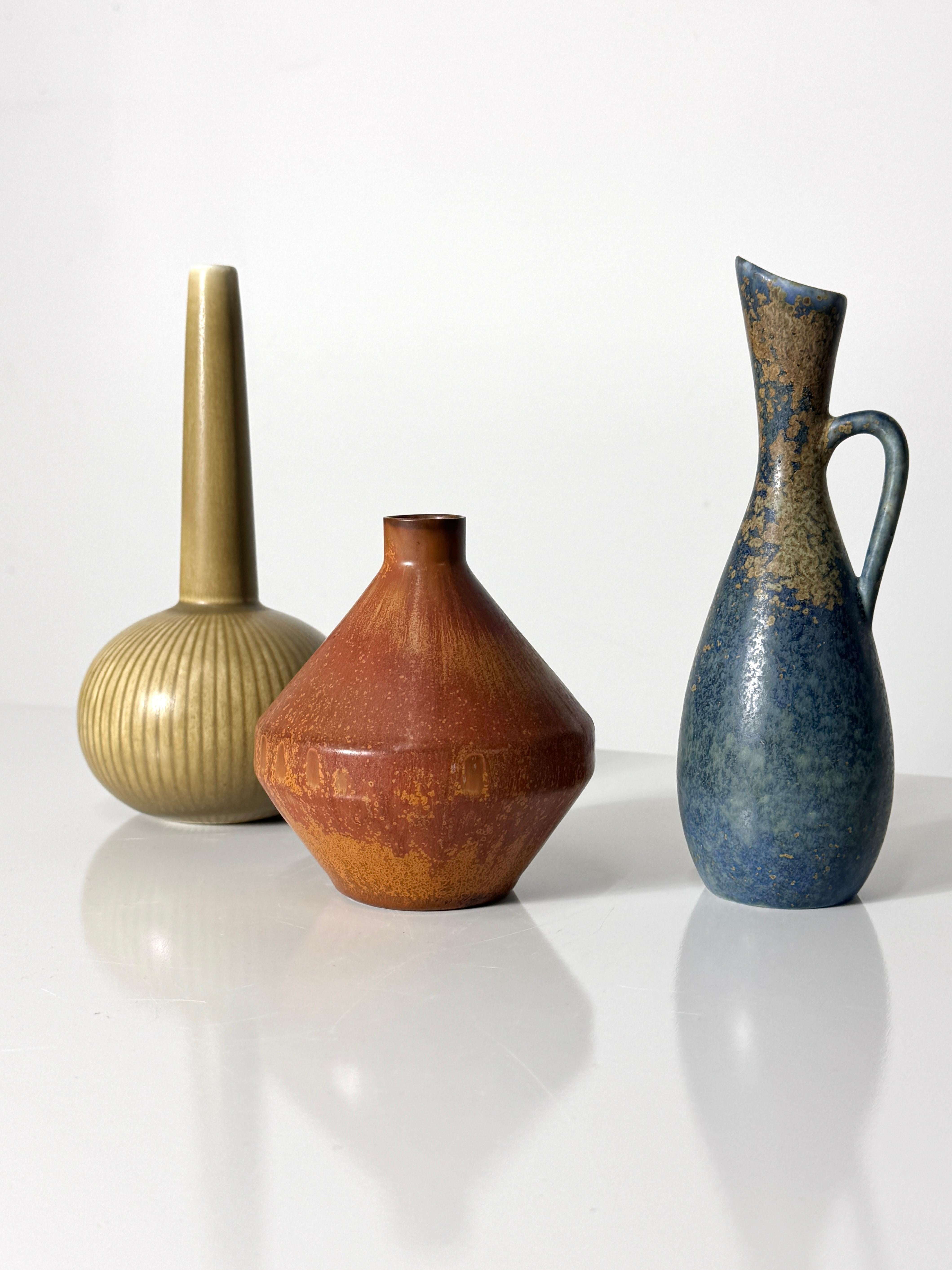 Superb grouping of three ceramic vessels by Rörstrand Sweden 
Circa 1950s

Pitcher form SYE vase in muted blue glaze by Carl-Harry Stalhane
4 inch diameter  4.5 inch height

Rust glaze SOU bud vase by Carl-Harry Stalhane
2.75 inch diameter  7.375