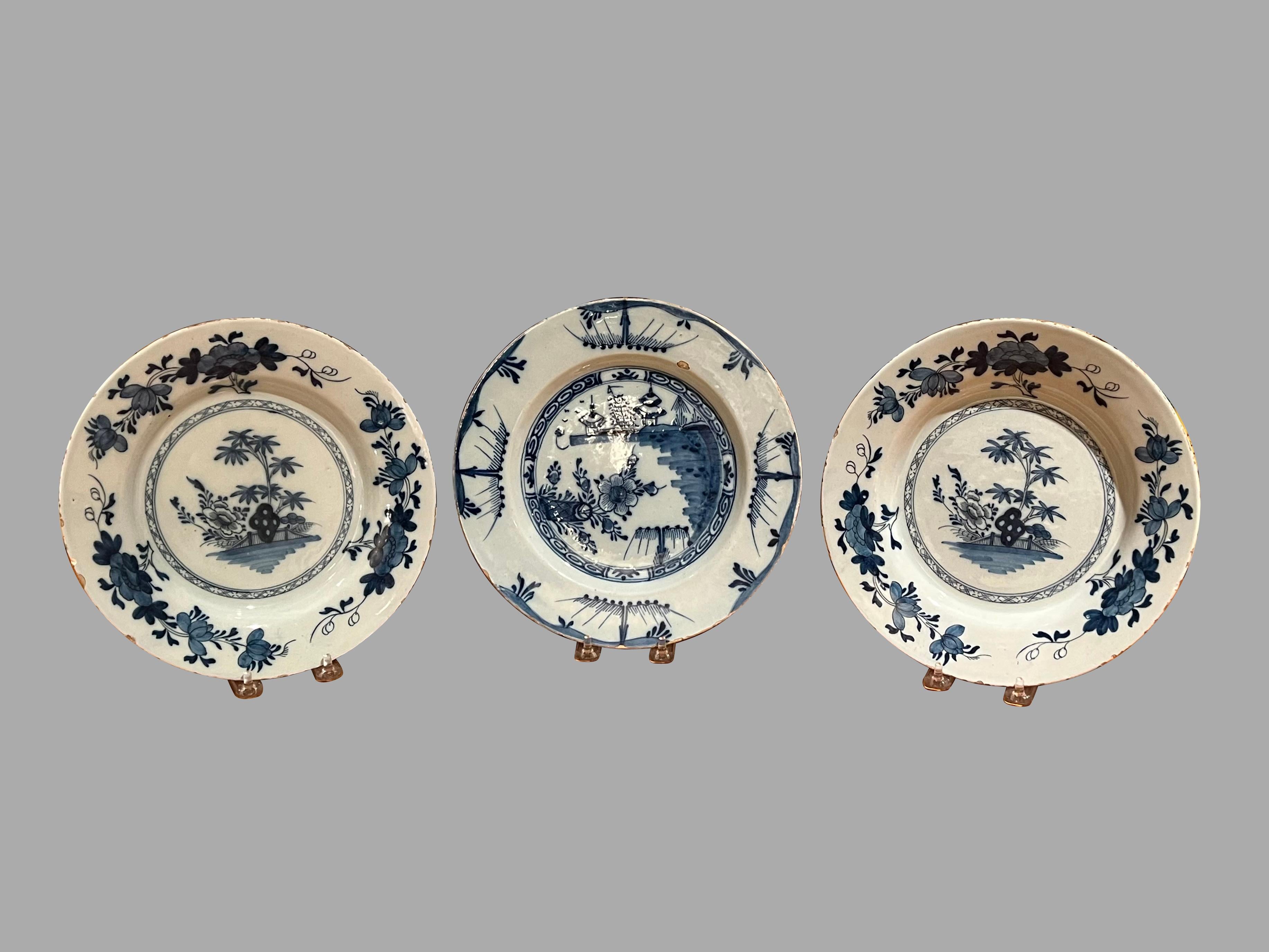 A grouping of 3 pieces of Delft blue and white earthenware plates, a pair and a single. All in the Chinoiserie taste. Each with hatchet mark on the reverse. Typical edge wear and glazing flaws as shown in images. Nineteenth century or earlier.