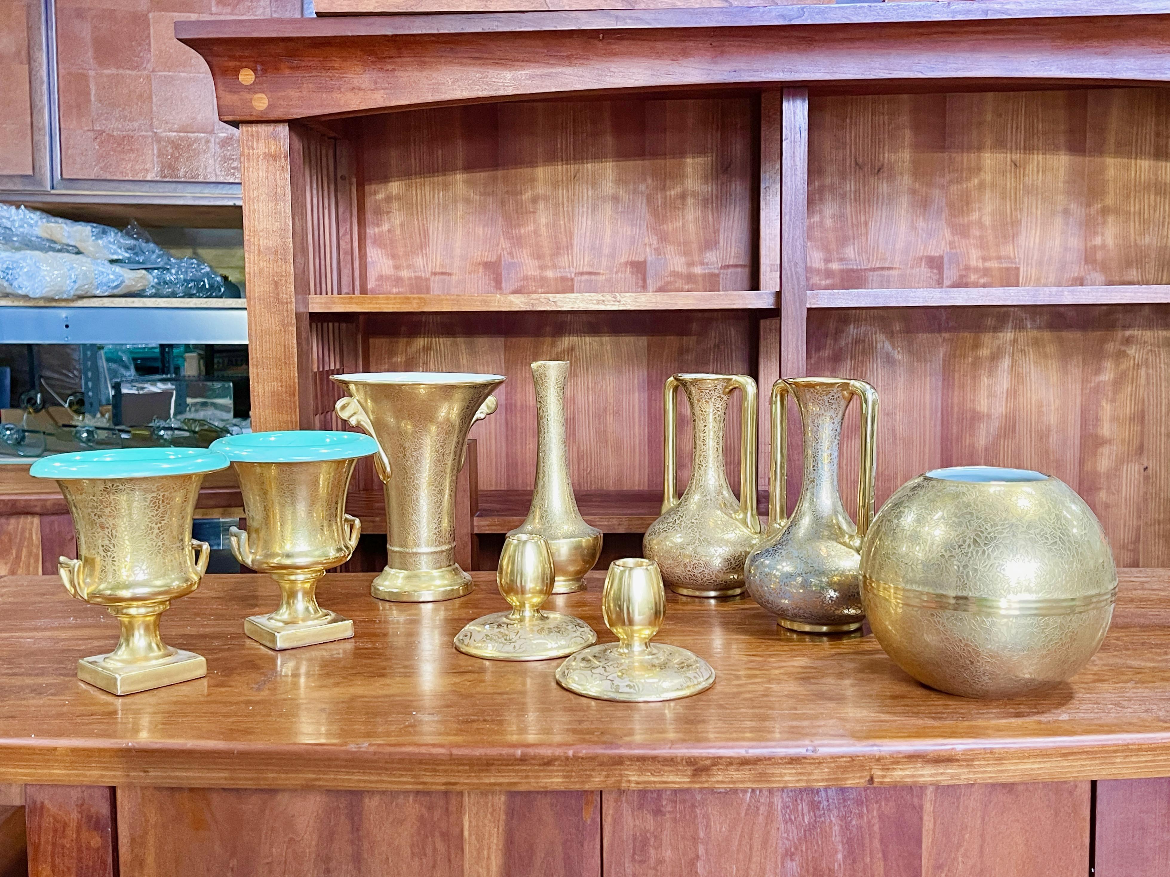 Grouping of nine art deco pieces (including three sets of pairs) by TAC Trenton Potteries and gilt decorated by Wheeling Decorating Co., including large orbit vase, pair of bud candle holders, pair of two handled vases, pair of footed urns and two