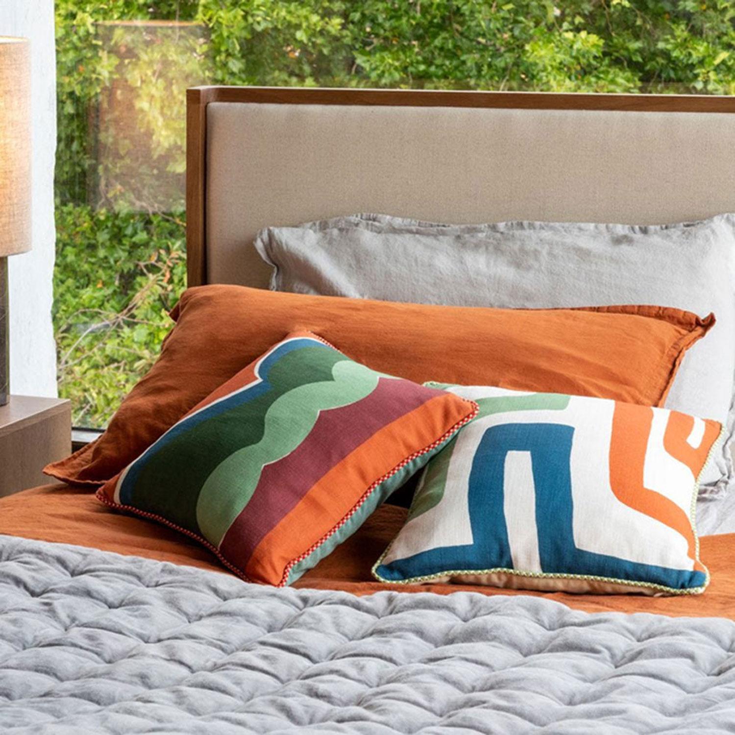 Grover has been created through an exploration of collage, playing with colour and shape. Printed onto linen the earthy tones reflect nature, finished with an orange and white braided cotton piping and green British velvet back. The linen cloth
