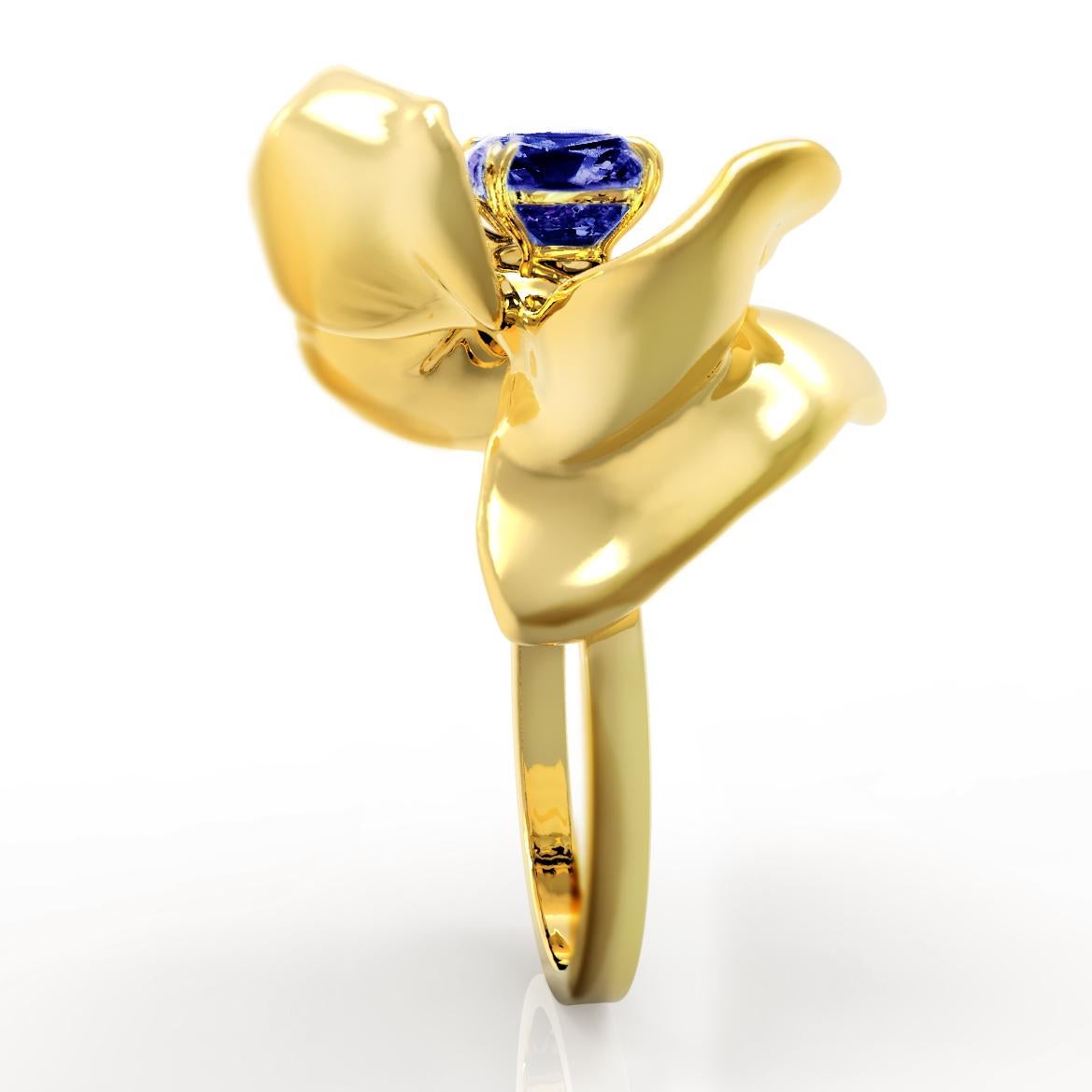 The Magnolia Flower contemporary engagement ring is crafted from 18 karat yellow gold and features a GRS certified no-heat vivid blue sapphire cushion weighing 1.09 carats. The ring's golden petals reflect light, framing the vivid blue sapphire