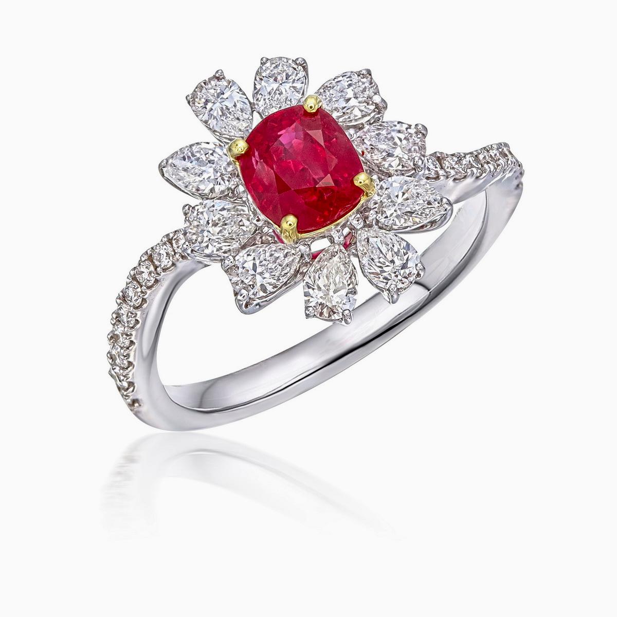 Presenting a cushion shaped ruby ring with pear shaped diamonds as petals, creating a stunning flower design. The center ruby is one of the most rare natural gemstones in the world of pigeon blood colour and is of 0.80 carats, the ideal size to wear