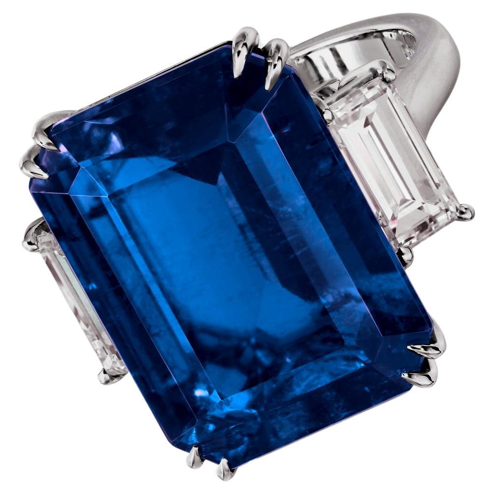 exceptional brilliance and rarity—a 8.28 carat emerald-cut vivid blue sapphire of Burmese origin, certified by GRS for its unparalleled hue and quality. 

Flanking this regal sapphire are two emerald-cut diamonds of D-E color and VVS1 clarity, their