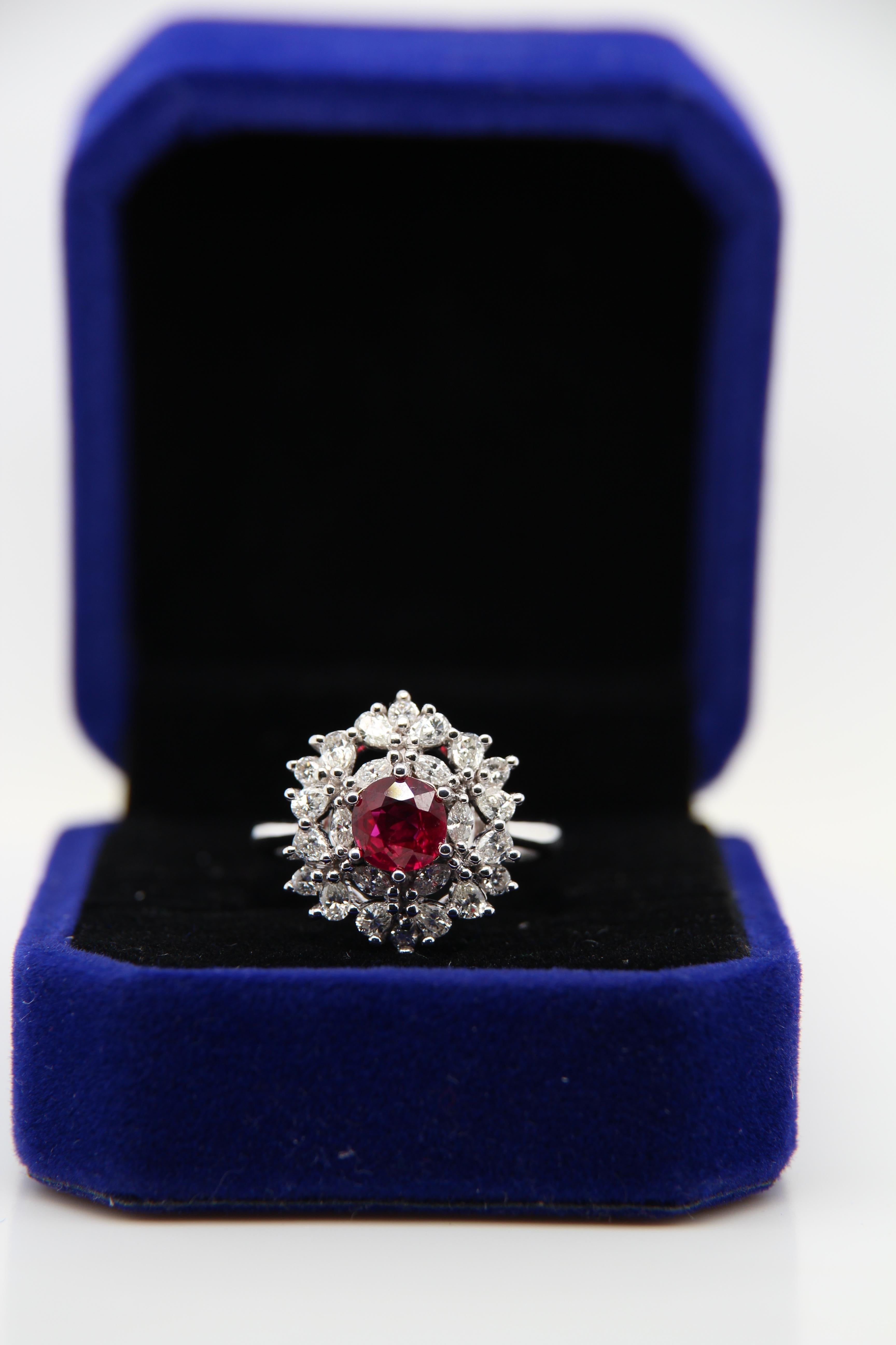 A Ruby and diamond ring. The ring's center stone is 1.08 carat pigeon blood Burmese ruby certified by Gem Research Swisslab (GRS). The center stone is surrounded by 0.95 carat mix shaped diamonds and mounted on 18K white gold gross weight 6.19 g.