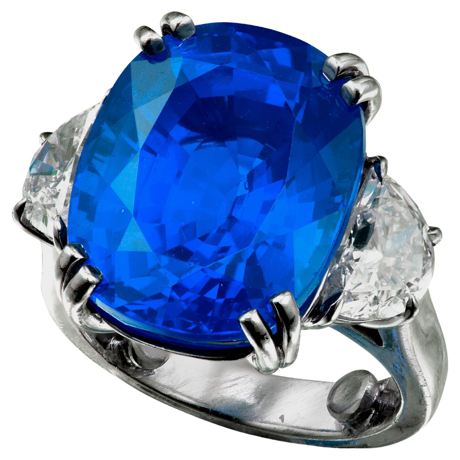 Centering a shaped cushion, framed by half moon diamonds

Sapphire weighing 12.88 carats
Diamonds weighing a total of approximately 0.75 carats
Size 7


