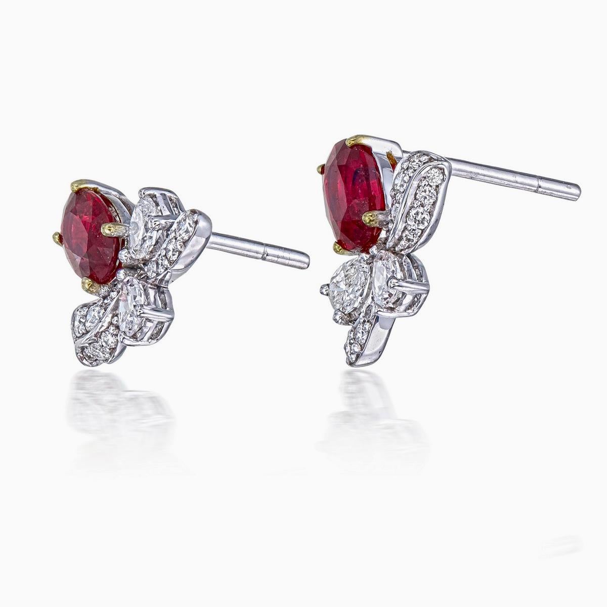 A pair of fine modern ruby and diamond earrings made in 18 Karat gold. This pair of earrings embraces minimalism with it's simple floral design while still displaying elegance; a great fit for lifestyle wear.

- There are two center oval Pigeon