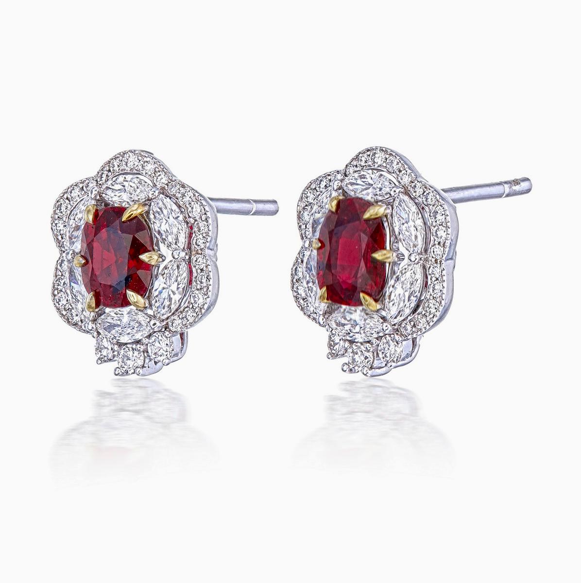 A pair of fine modern ruby and diamond earrings made in 18 Karat gold. This pair of earrings embraces minimalism with its simple floral design while still displaying elegance; a great fit for lifestyle wear.

- There are two center oval Pigeon Blood