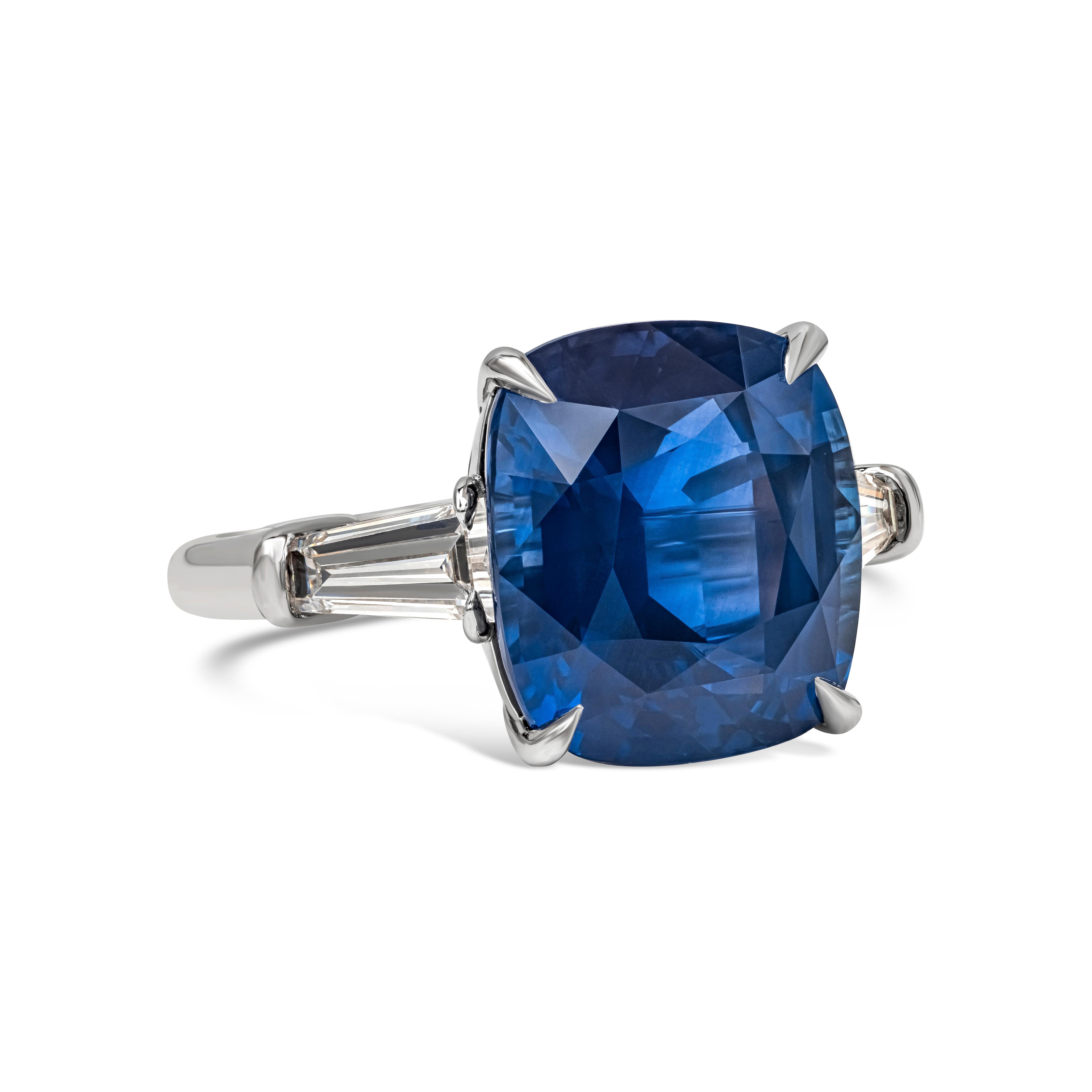 An elegant three-stone engagement ring, featuring a GRS certified 14.67 carats cushion cut vivid blue Sri Lankan sapphire. Flanked by tapered baguette diamonds weighing 1.19 carats total with D-E color and VS clarity. Set on a polished platinum