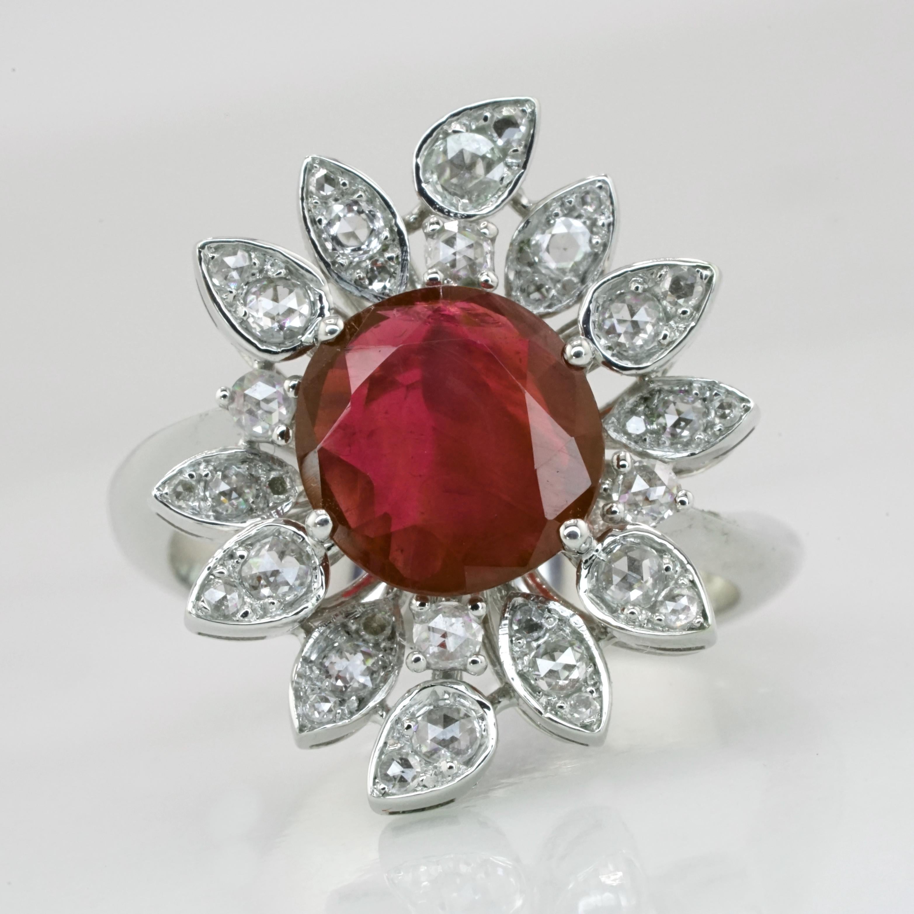 This exquisite ring features a central oval-cut 1.93-carat unheated Burmese ruby, certified by GRS, exuding a deep and vibrant red hue. 

The ruby is elegantly framed by a halo of meticulously arranged pear and marquise-cut diamonds, enhancing its