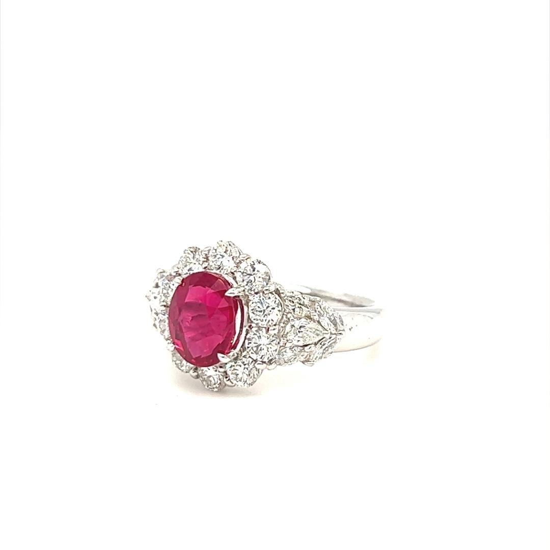 This magnificent ring features a 1.95 carat heated Burmese ruby and 1.26 carat in total of mixed cut colorless diamond; 10 round brilliant cut, 8 marquise and 2 pear shaped diamonds with F color and VVS clarity. The ring is crafted in platinum and