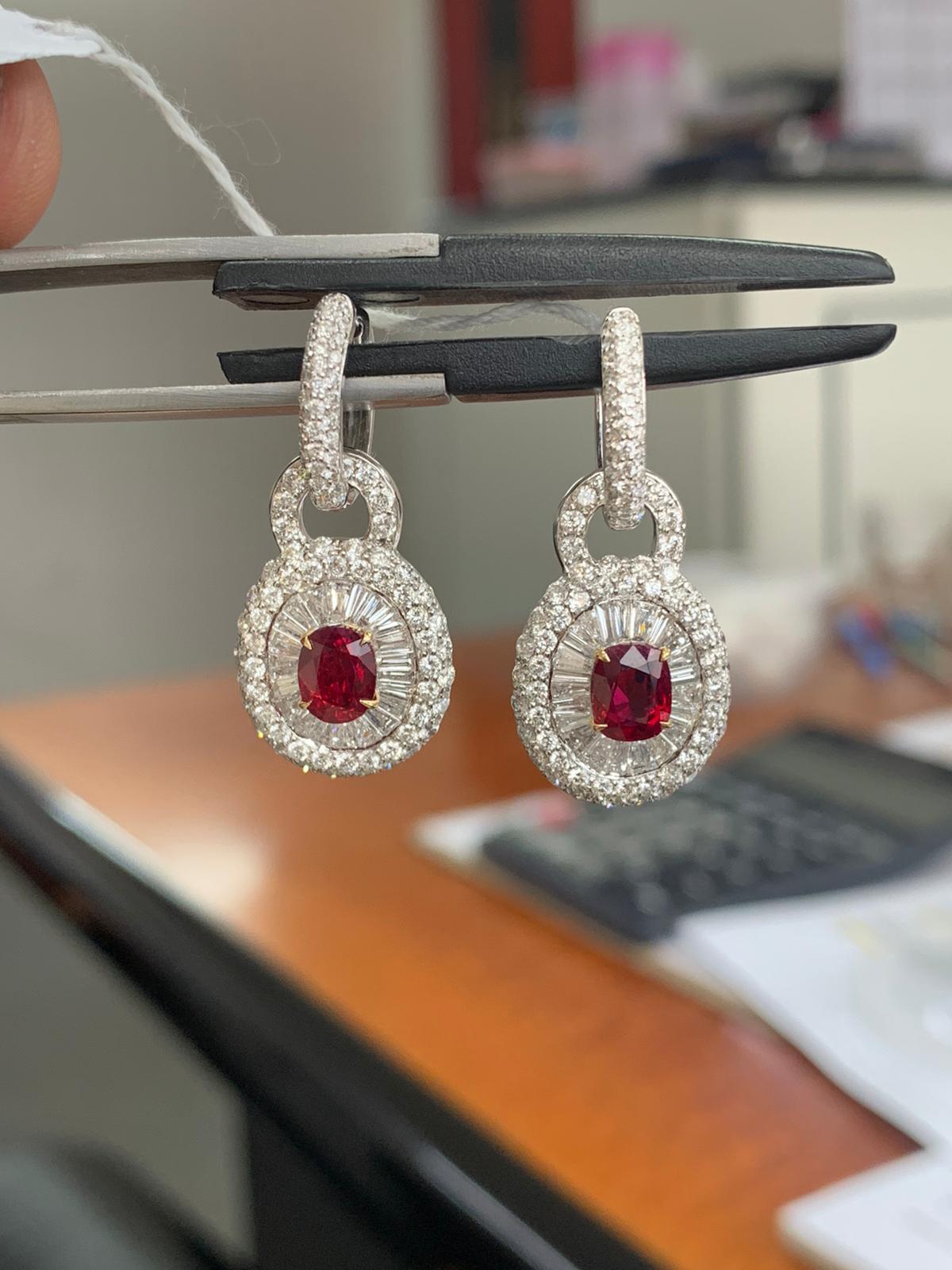 A brand new ruby and diamond earring by Rewa. The rubies weigh 1.22 and 1.14 carat each and they are both certified by Gem Research Swisslab (GRS) as natural, no heat, and 'Pigeon Blood'. The rubies are surrounded by 3.11 carat diamonds on 18k white