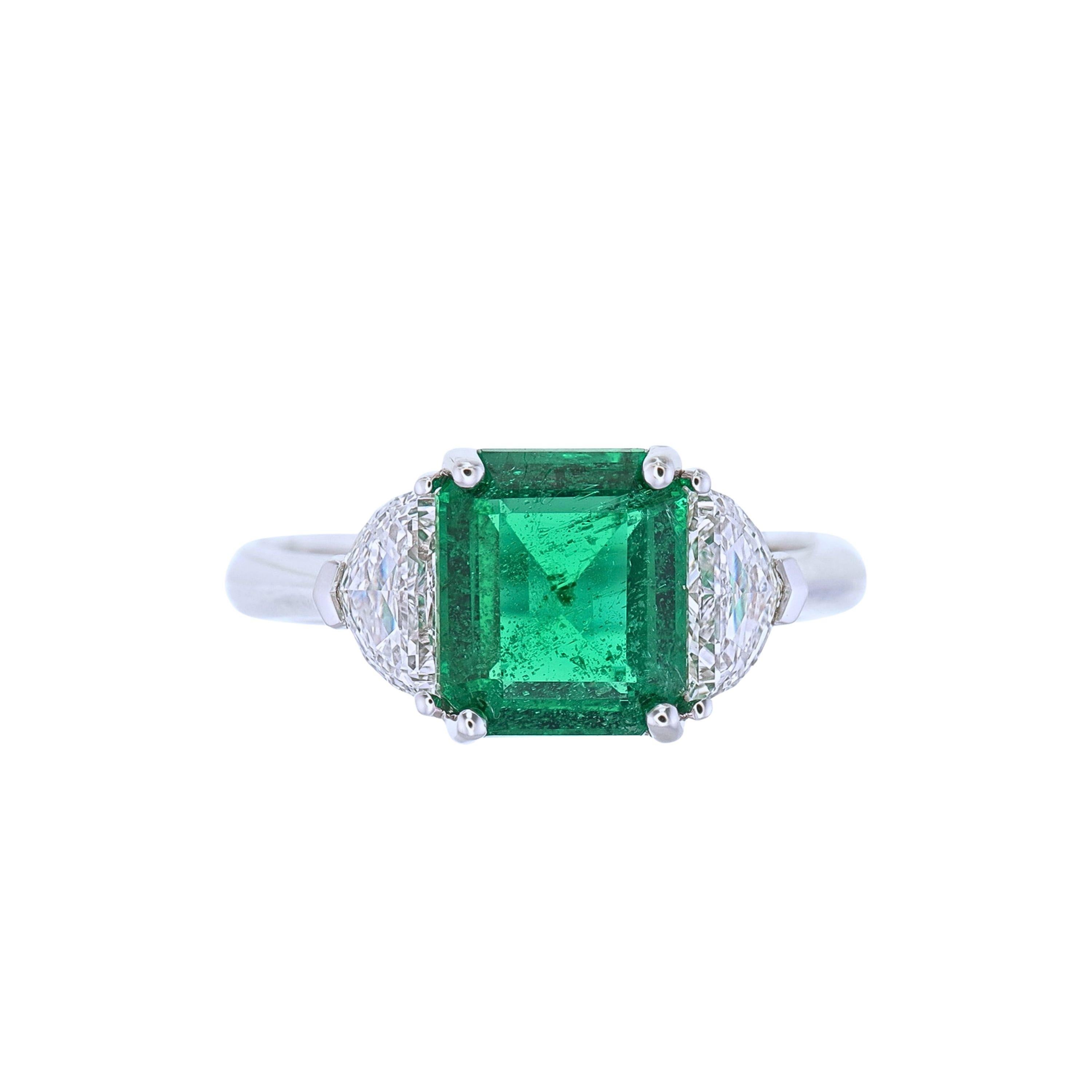 Introducing the GRS Certified 2.21 Carat Insignificant Oil Vivid Green Emerald and Diamond Three-Stone Ring, a stunning showcase of luxury and exquisite design. At its heart lies a 2.21-carat vivid green emerald, known for its vibrant color and