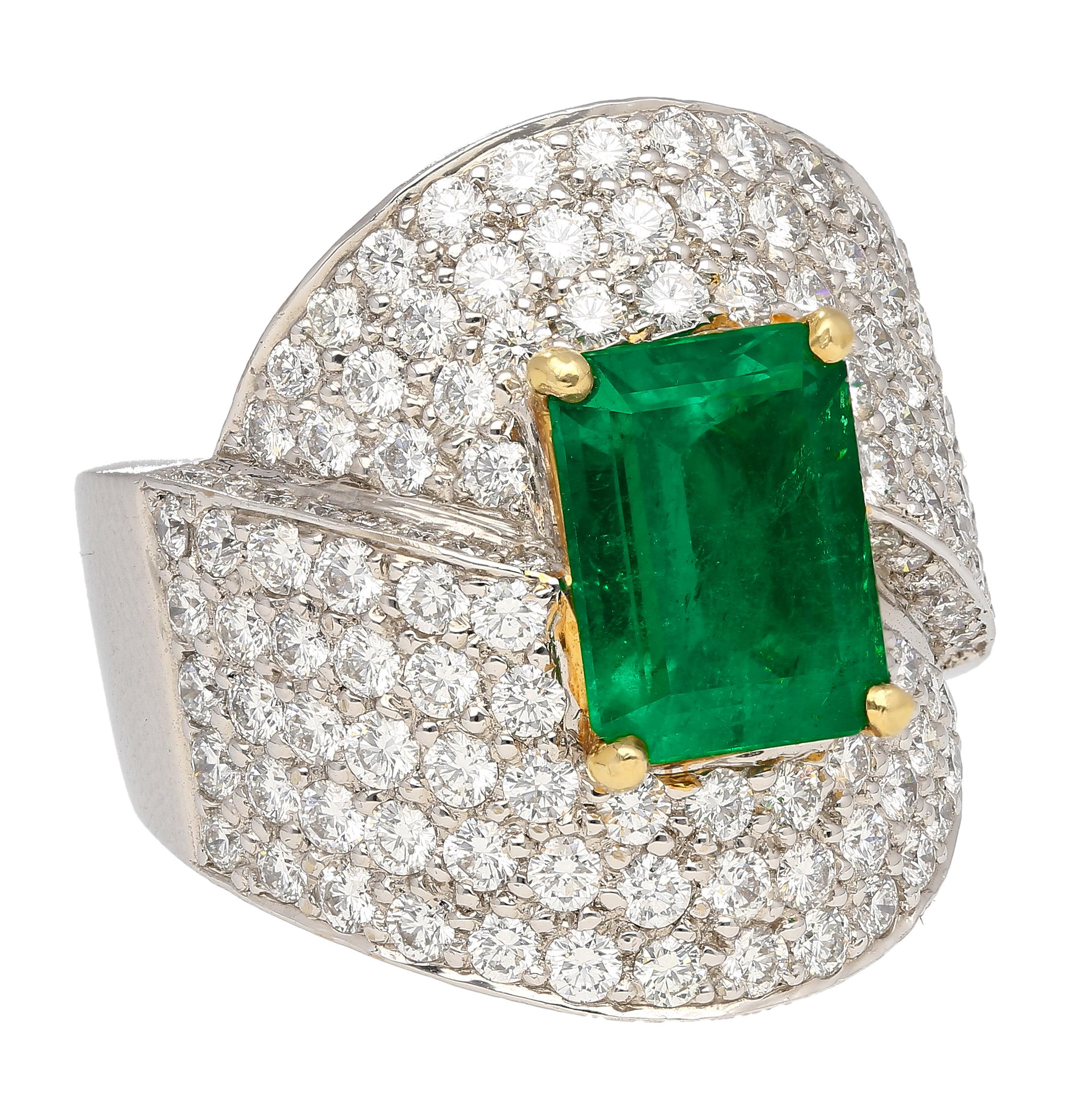 2.53-carat vivid green emerald cut natural emerald with 'minor' oil treatment. Set in 18k solid gold and 2.38 carats in round cut diamonds that form a stunning bypass ring design.

This Emerald was sourced from the famous Muzo Mine, located in the