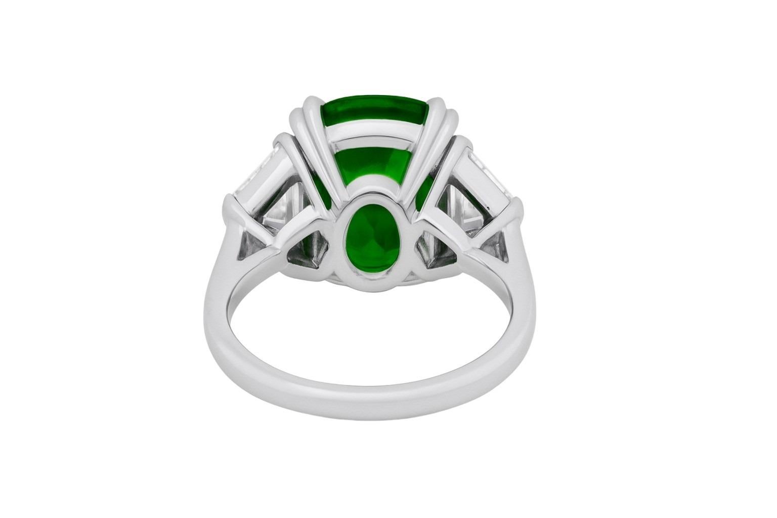 A masterpiece of timeless elegance, this exquisite ring showcases a striking 2.64-carat cushion shaped emerald of vivid green hue, certified insignificant oil by GRS. 

Flanking the center stone are two perfectly matched cadillac-shaped diamond side
