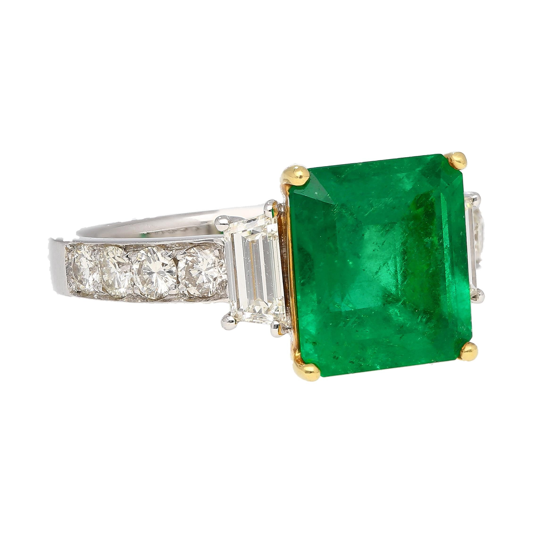 18K white and yellow gold prong-set emerald and diamond ring. Featuring a significant 3.16 emerald cut Colombian emerald with Vivid Green color and minor oil treatment.  GRS certified with additional appendix letter. This emerald gem is a true