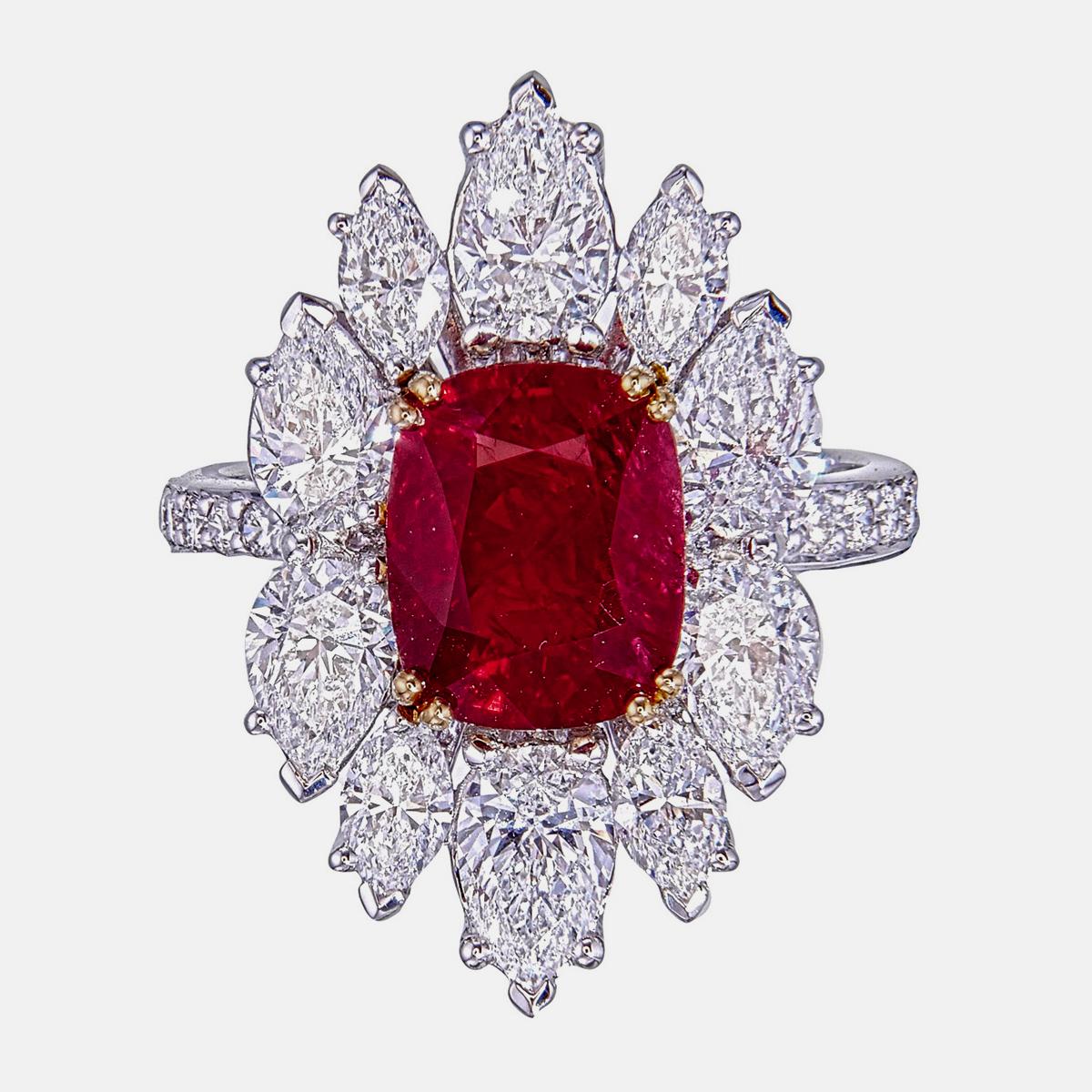 Der elegante Ring von Rewa Jewels ist aus 18 Karat Weißgold gefertigt.

In der Mitte befindet sich ein Burma No Heat Pigeon Blood Ruby im Kissenschliff mit einem Gewicht von ca. 3,28 Karat.
Es ist von der GRS zertifiziert, die Kopie des Zertifikats