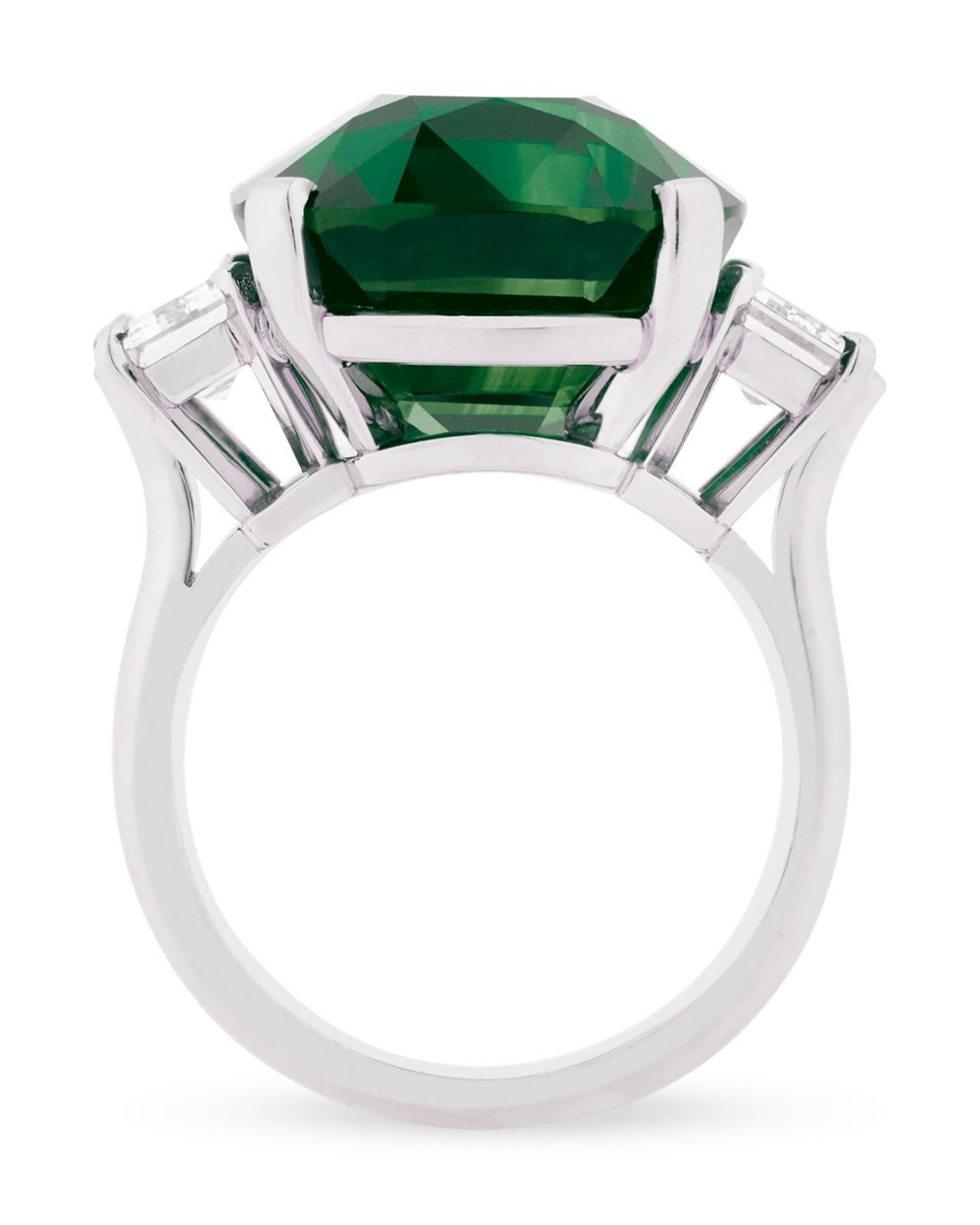 An exquite Rectangular emerald-cut sapphire of 3.43 carats insignificant oil emerald with trapezoid side diamonds.

