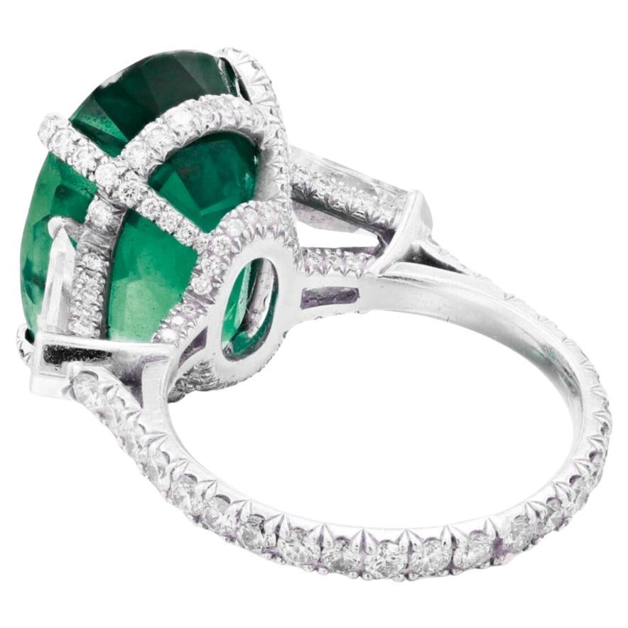 Centering an oval-shaped emerald, flanked by two shield-shaped diamonds, decorated throughout with round diamonds.

emerald weighing 3.96 carats
Size 6
Platinum
Accompanied by Grs report  stating that the emerald is of Zambian origin, with vivid