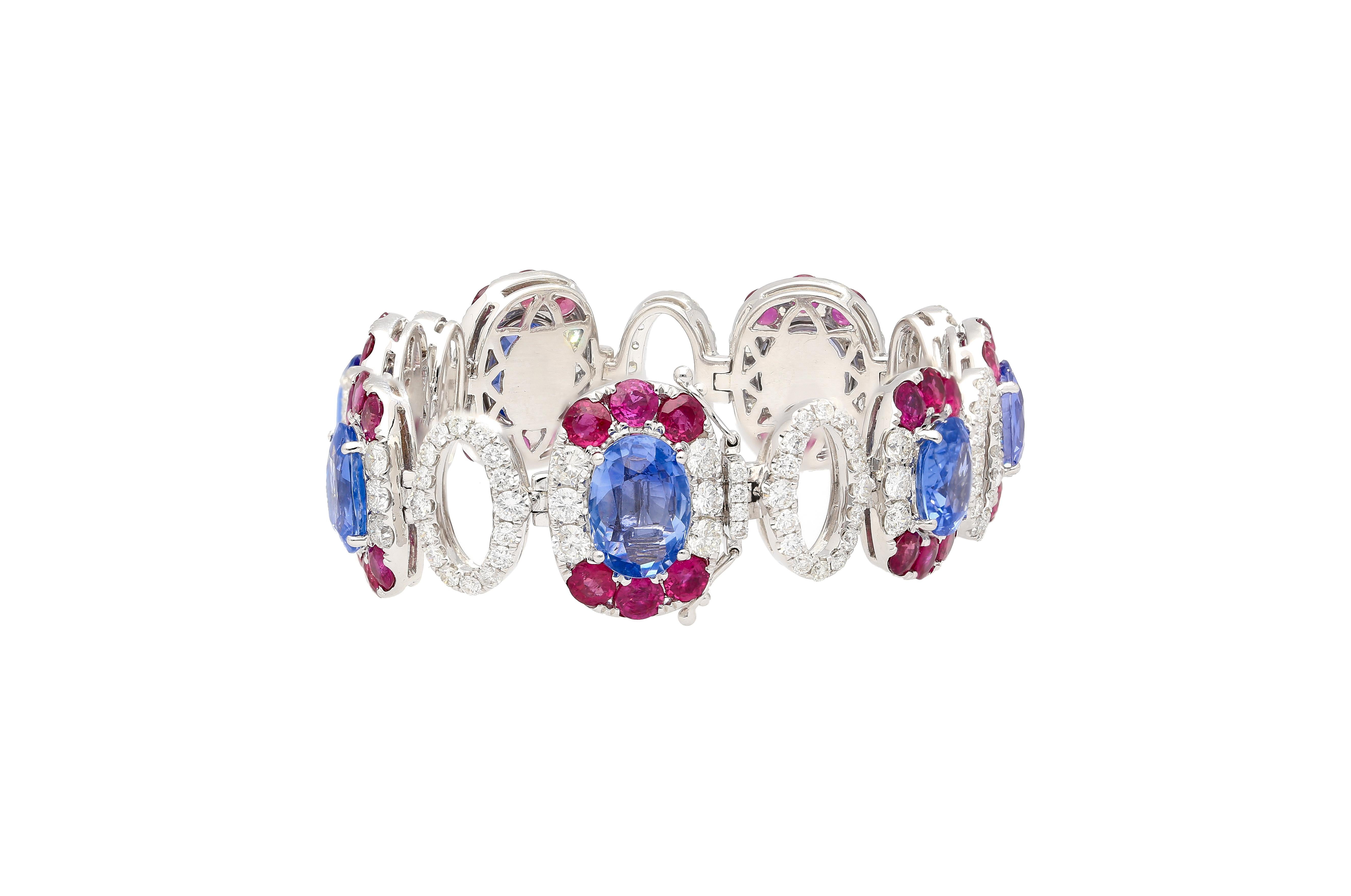 18k white gold oval shaped multi gemstone link bracelet. Featuring 7 oval cut no heat natural blue sapphires. Each of which is GRS certified. 

Enhancing the bracelet's opulence are 154 round-cut Diamonds totaling 6.93 carats and 42 round-cut Rubies