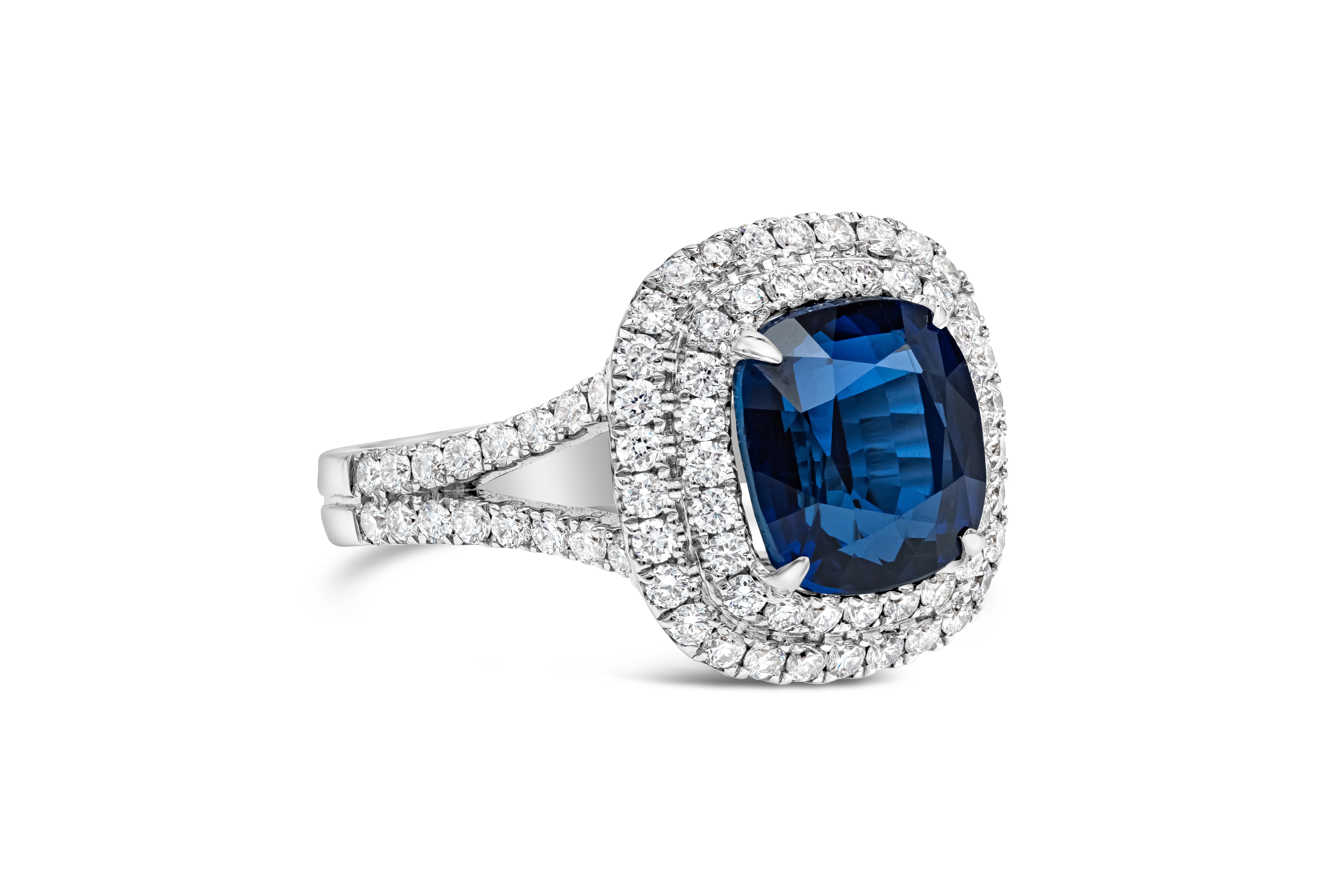 Features a color-rich cushion cut blue sapphire weighing 5.05 carats, surrounded by two rows of round brilliant diamonds in an 18k white gold split-shank mounting accented with diamonds. Accent diamonds weigh 1.00 carats total. Sapphire is certified