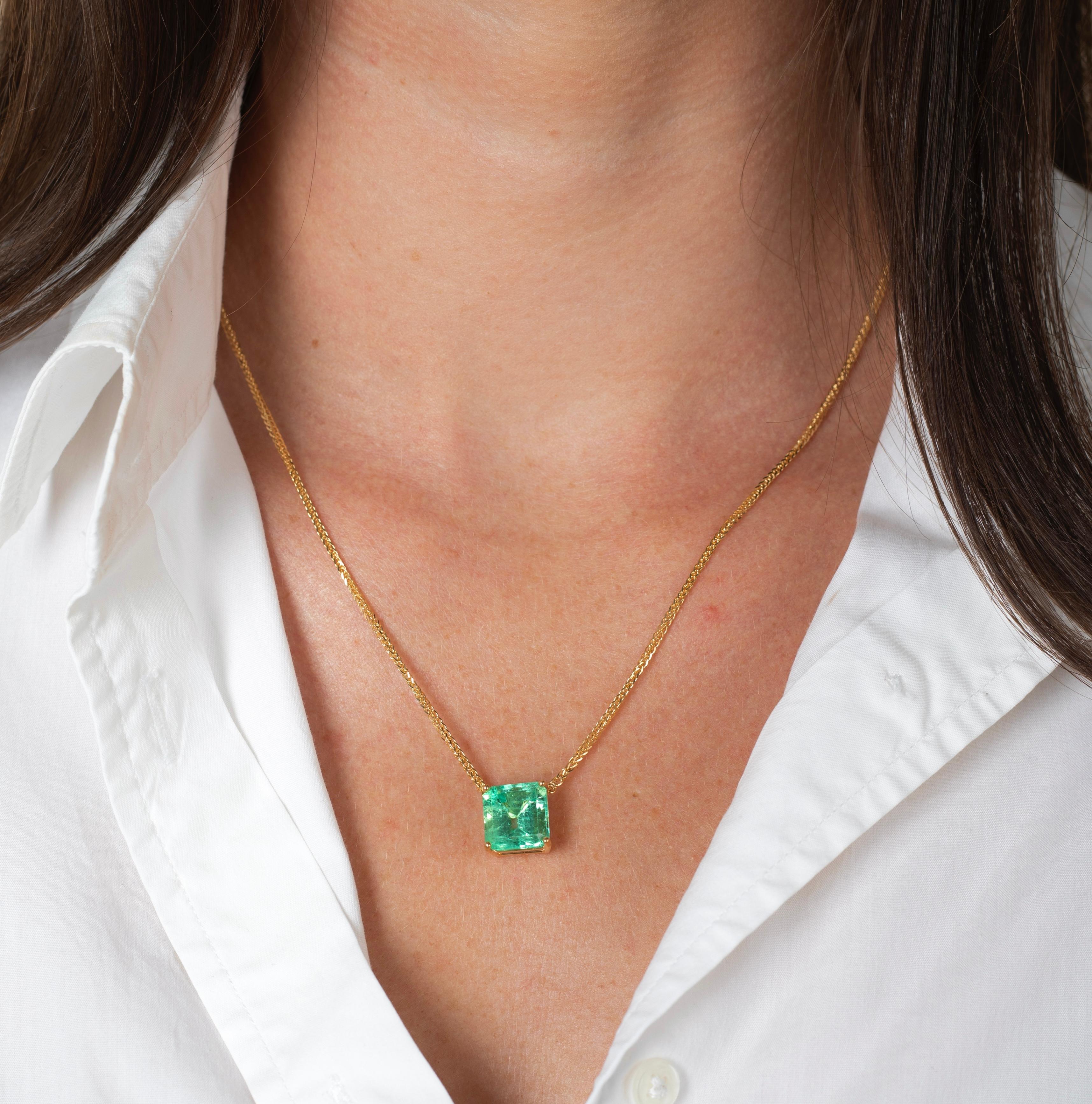 5.83-carat natural emerald solitaire floating pendant necklace. Seamlessly stationed on an 18k gold wheat chain with lobster clip closure. Yellow gold offers a gorgeous contrast to the vibrant pastel green color saturation of the center stone.

This