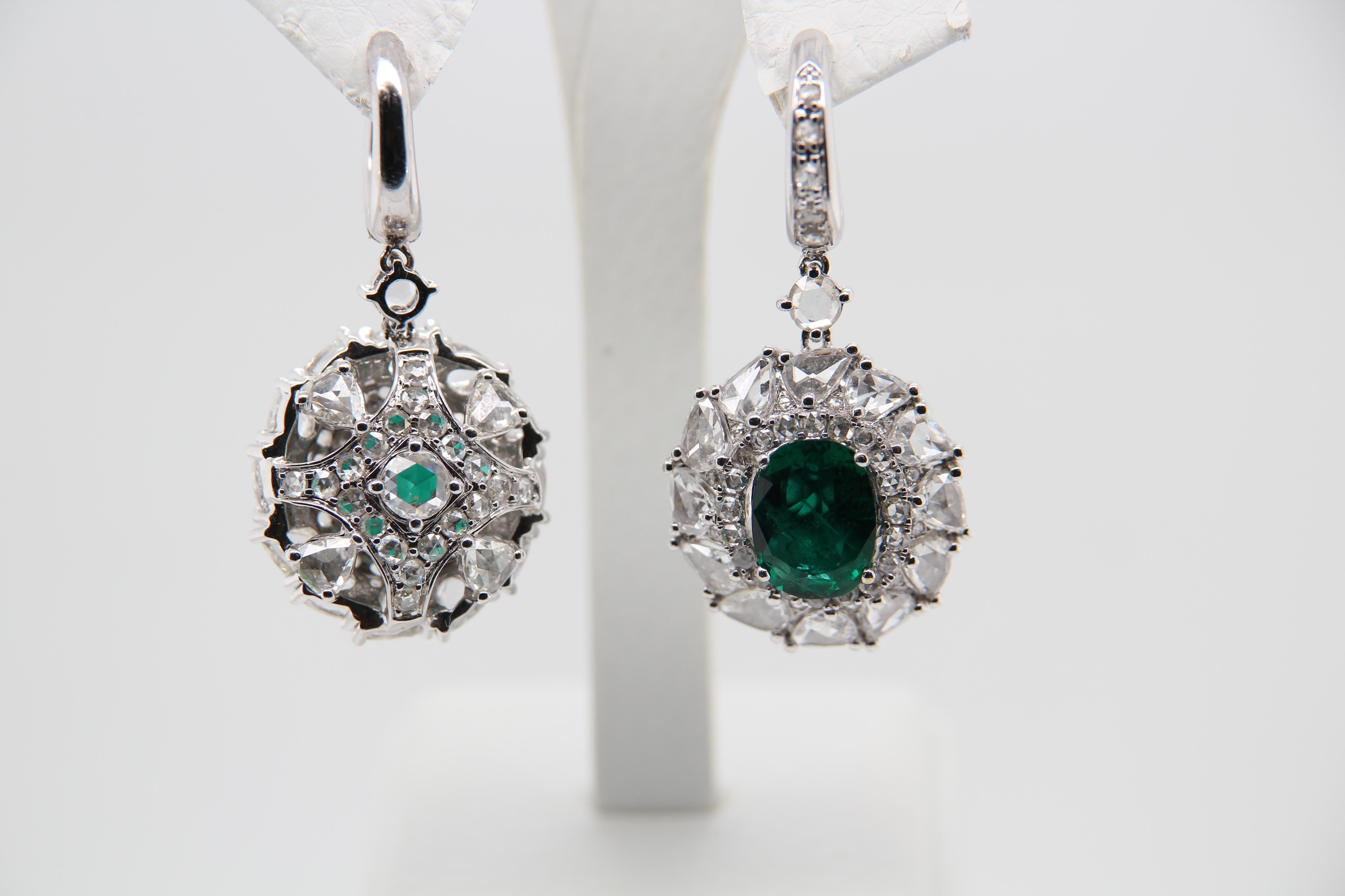 An emerald earring pair. Oval shaped Zambian Emeralds with insignificant oil weighing 2.79 Carat and 3.08 Carat individually and diamonds weighing 8.48 Carat. Made in 18k white gold 21.68 g gross weight.