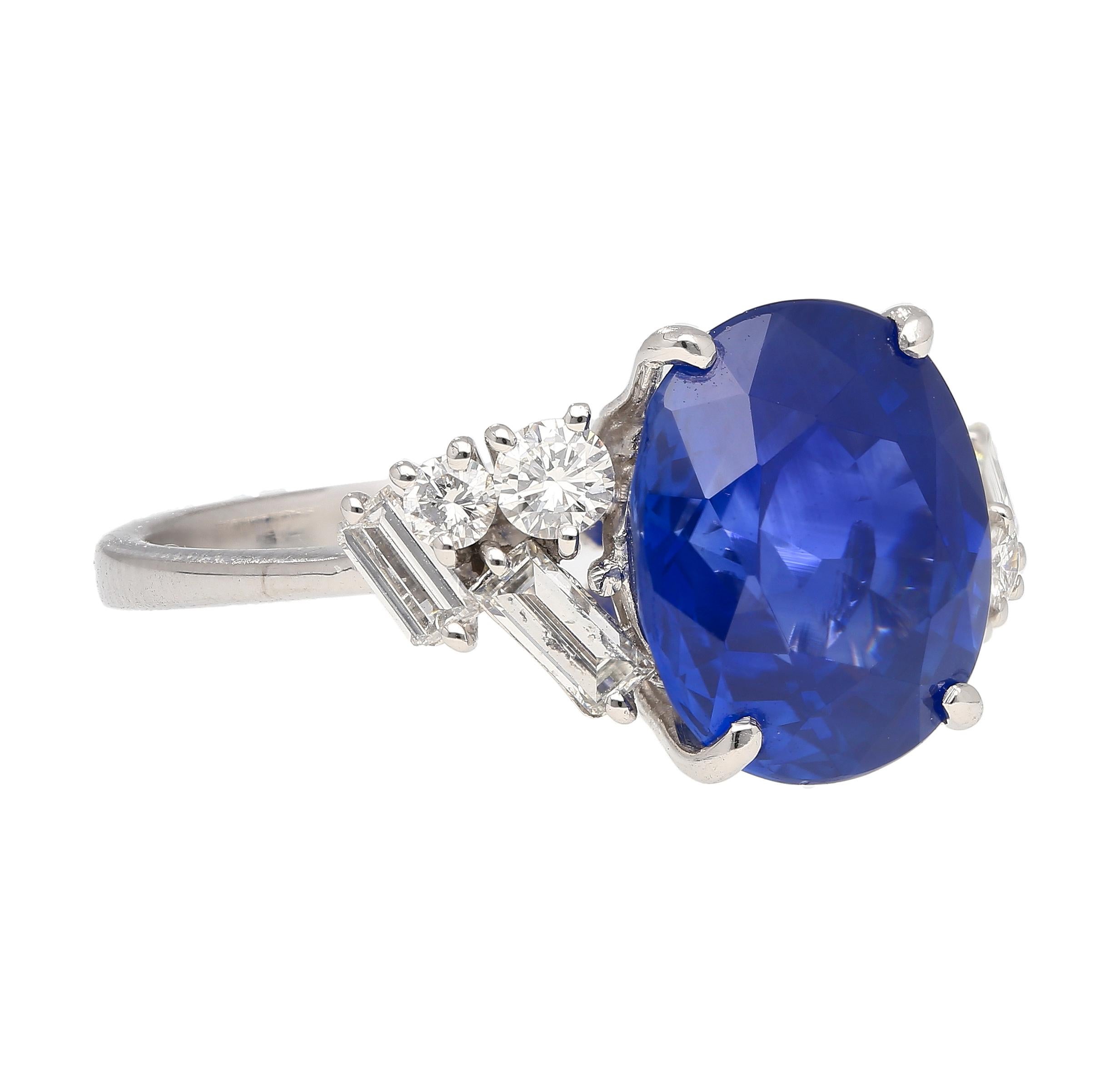 This ring features a natural 6.35-carat oval cut Royal Blue Sapphire from Ceylon, Sri Lanka. Set in platinum, with 4 round cut and 4 baguette cut floating cluster diamond side stones. The center stone has been identified by GRS labs to have 