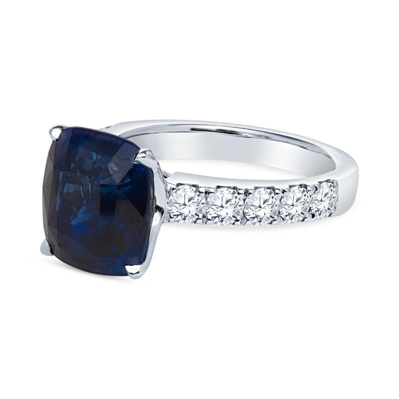 This beautiful ring features a 6.44 carat GRS certified cushion cut vivid blue sapphire from Sri Lanka. It is accented by 0.96 carat in round brilliant split prong set diamonds halfway down the shank set in 18 karat white gold. This is is