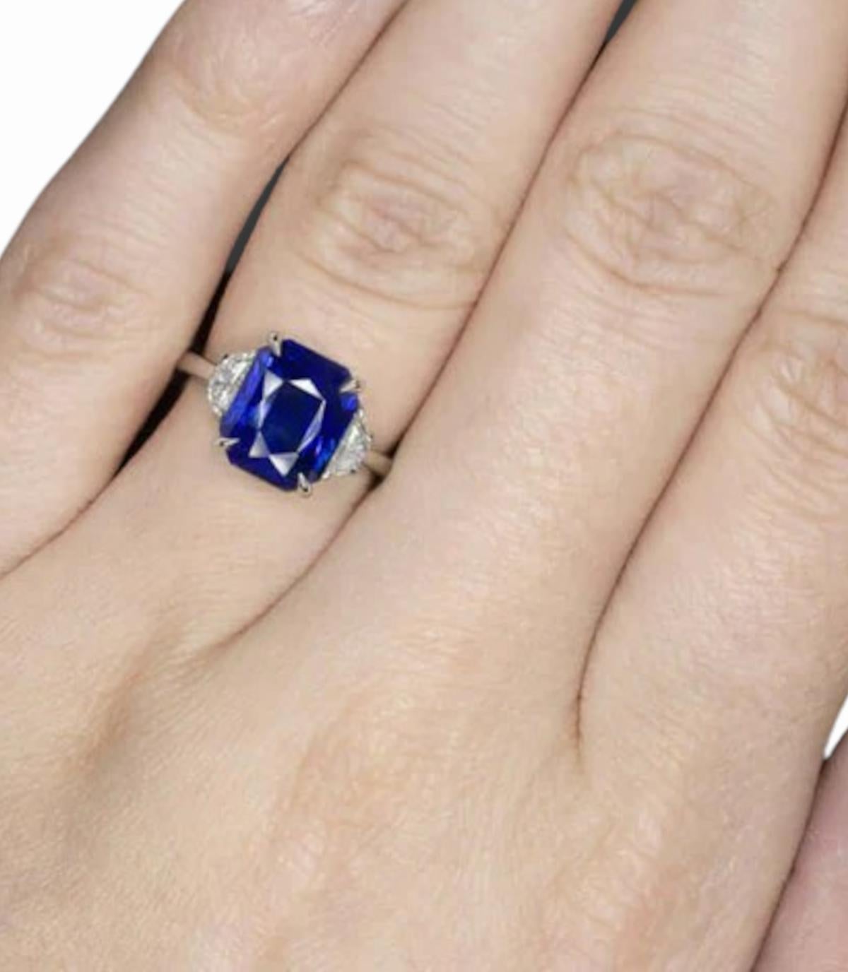 This breathtaking ring features a majestic 7.15-carat natural blue sapphire, originating from the famed gemstone mines of Sri Lanka. Cut in a unique octagonal step style, this sapphire boasts a deep blue hue that is both intense and vibrant,