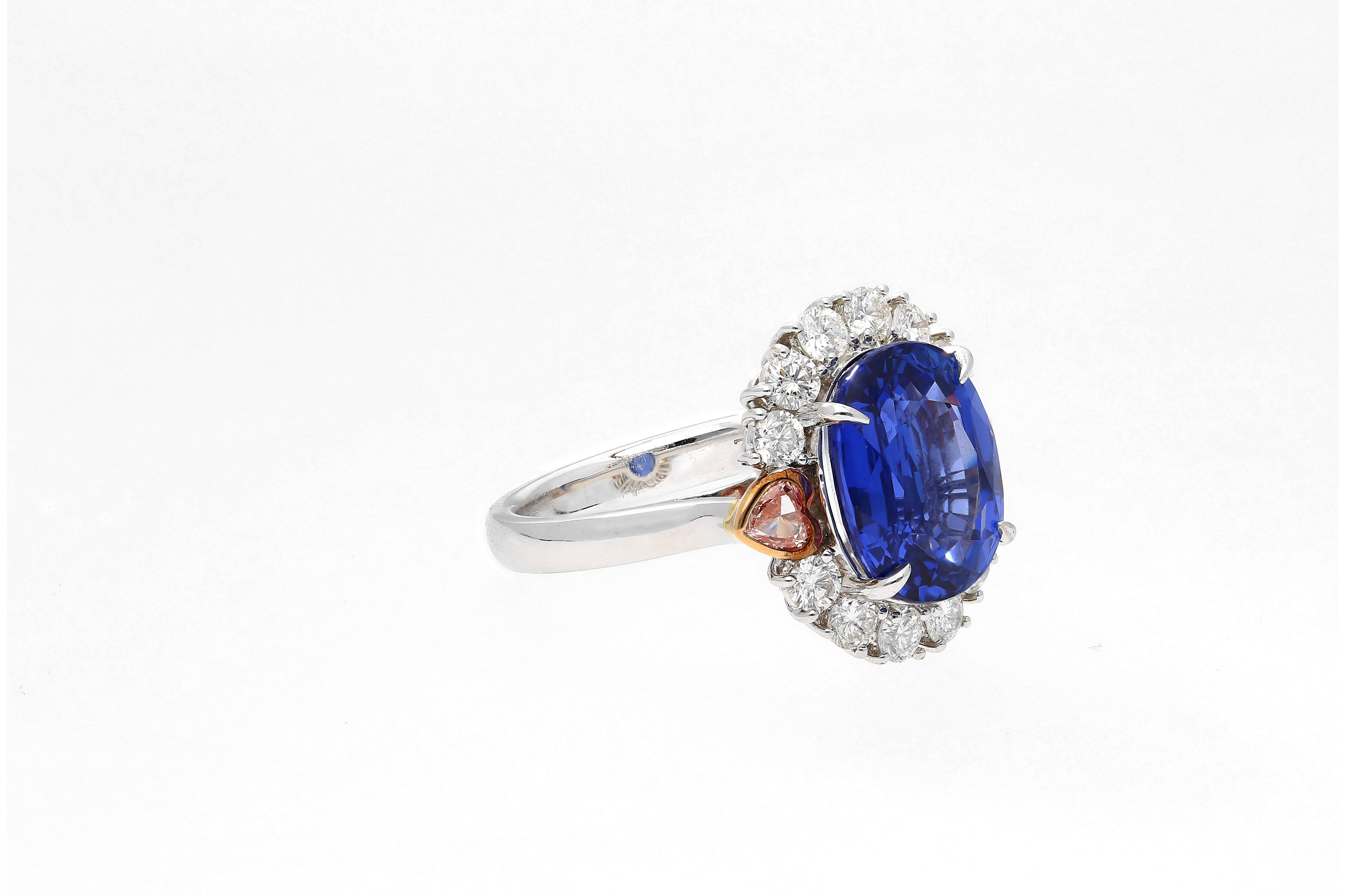 Centering an 7.25 Carat Cornflower Blue Ceylon (Sri-Lanka) Sapphire, accented by Heart-Shape Pink Diamonds and Round-Brilliant Cut White Diamonds, and set in 18K White Gold, this unique modern gem is a testament to the fantastic design team at Gad &