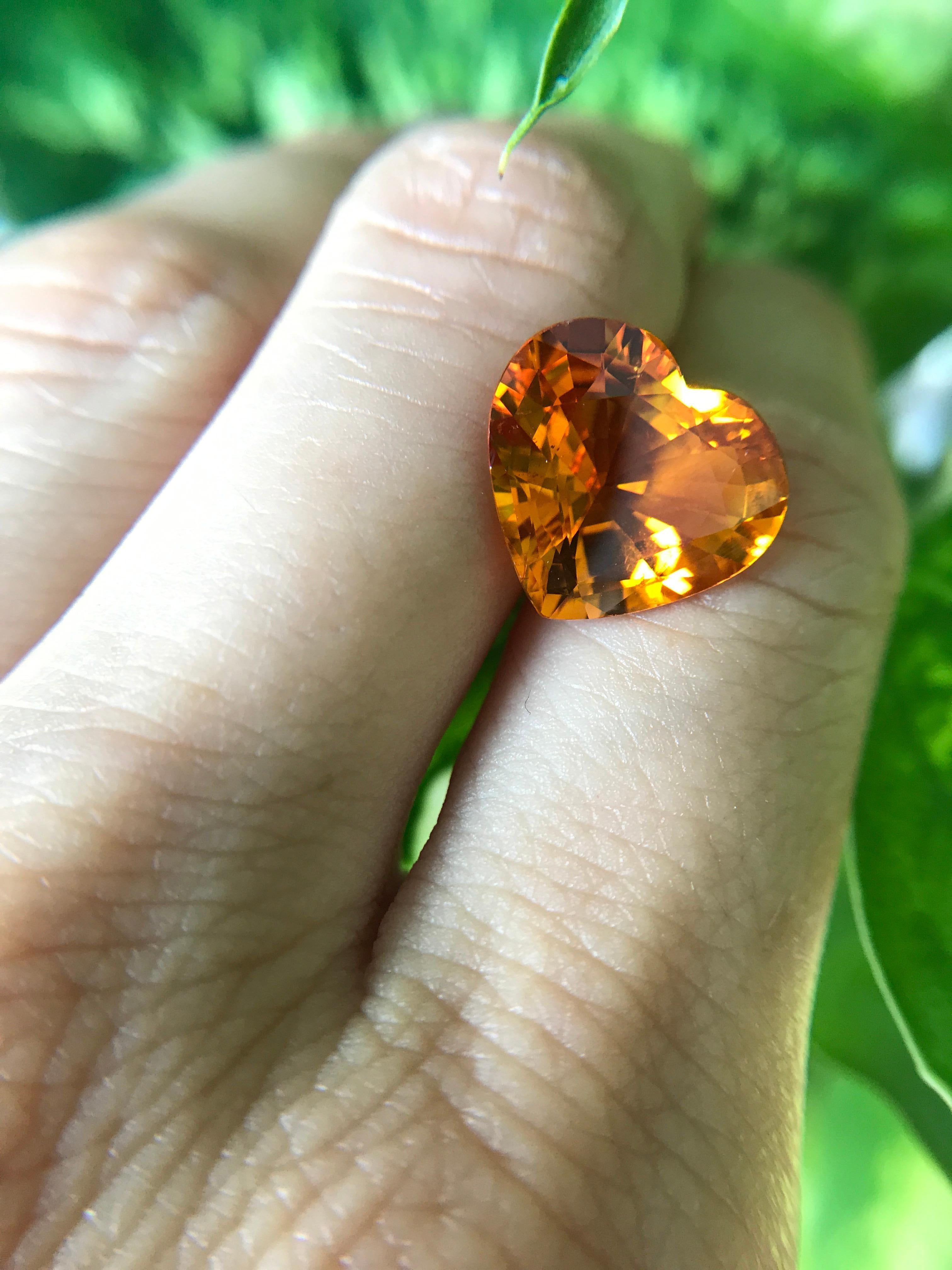 Bright 8.45 carat natural heart-shaped fancy sapphire in a vivid orangy-yellow colour. This sapphire is perfect for a modern pendant or stylish ring.

We specialise in colour gemstones and offer a bespoke jewellery service. The production time for