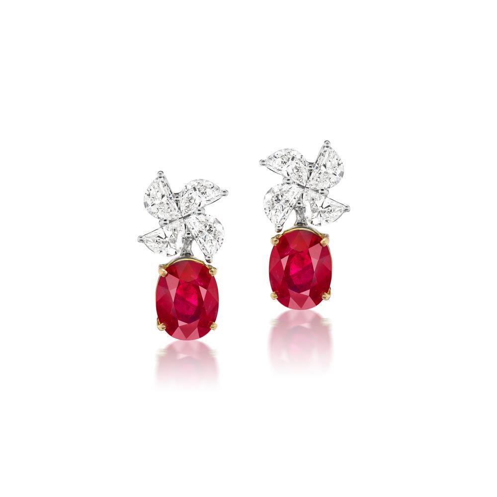 Under a windmill of polished glimmering half-moon diamonds, 2.50 ct, sit 2 beautiful GRS certified Burmese Pigeon Blood Rubies each 3.23 cts. and 3.13 cts. each. 18k White Gold.