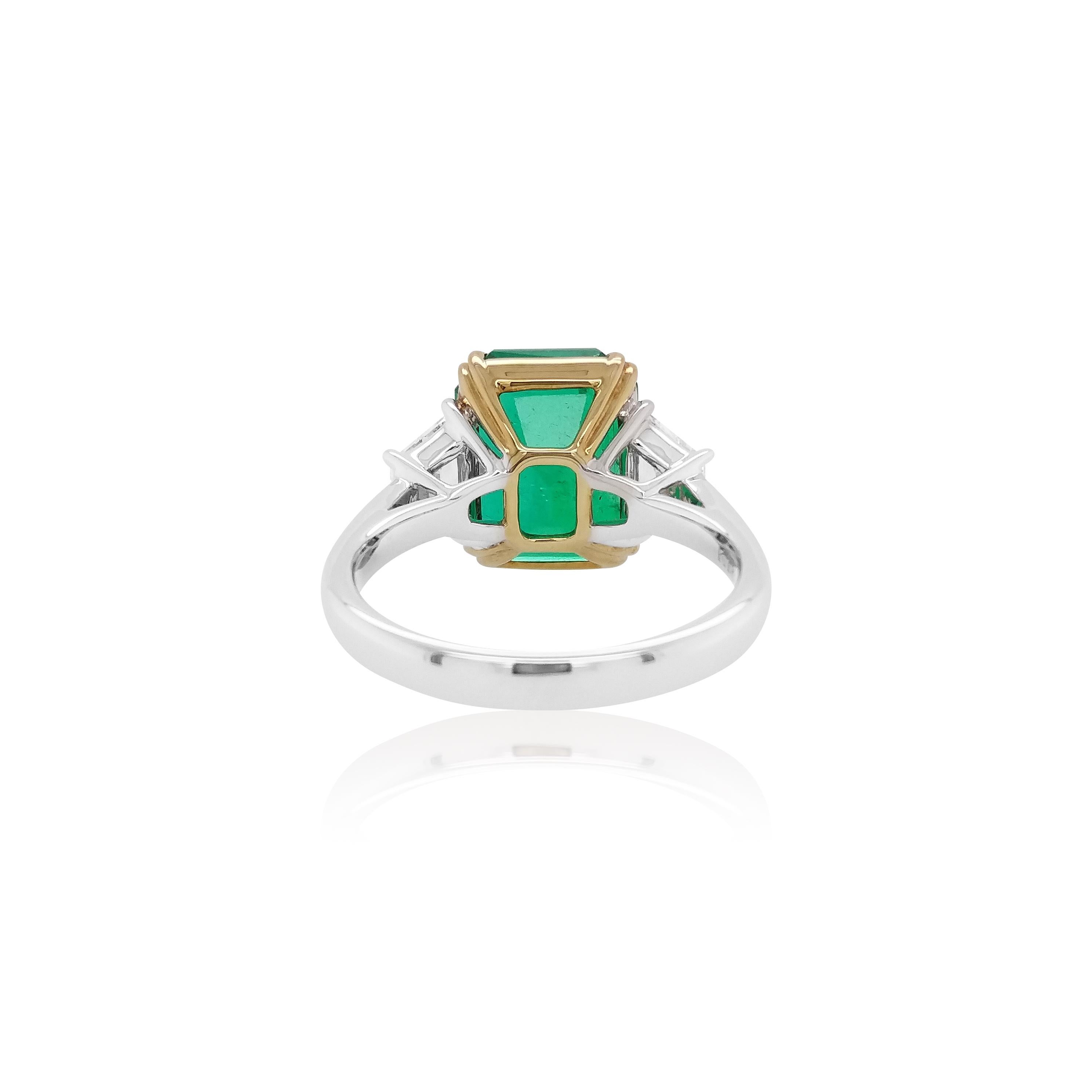 This unique ring features a spectacular Colombian Emerald, which is perfectly set between two trapezoid White Diamonds. This striking ring will add a touch of contemporary elegance to any outfit it is paired with.
-	Emerald-Cut Natural Colombian