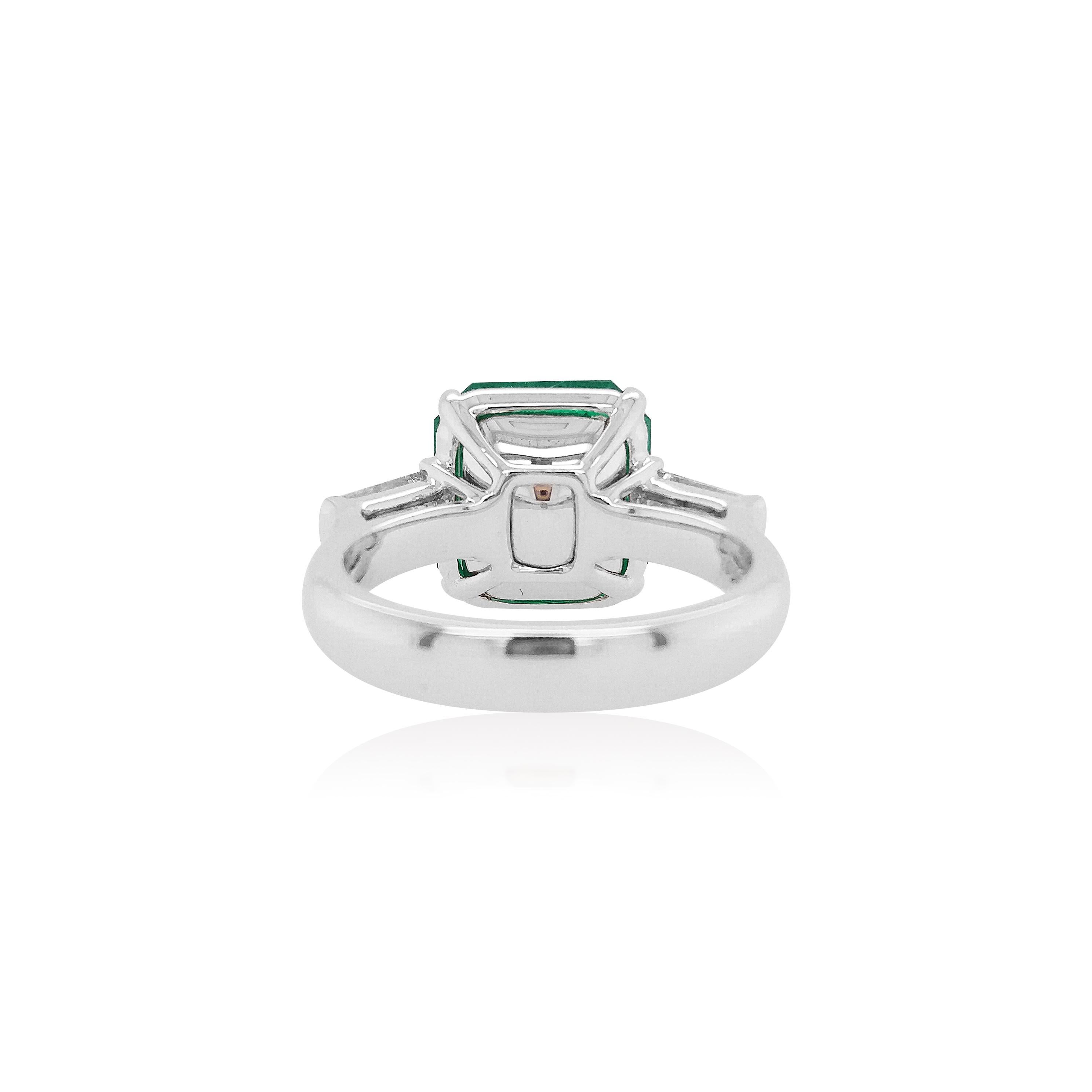 This striking ring features an exceptional Colombian Emerald at its centre, flanked by two tapered baguette White Diamonds. Set in PT900 platinum to provide a unique, but elegant contrast to the rich color of the Emerald, this piece is truly one of