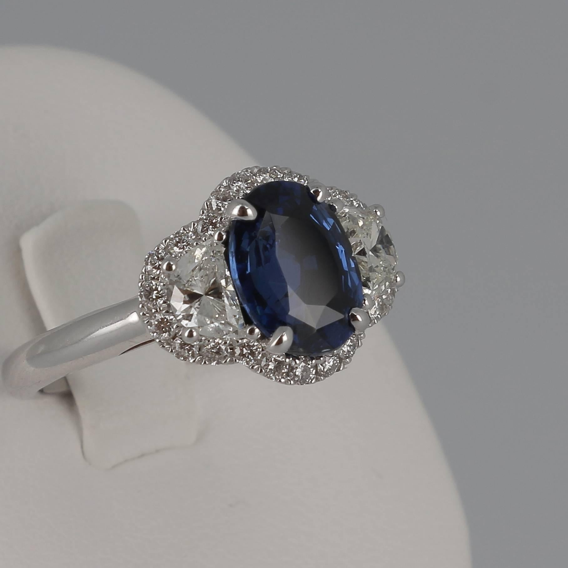 An amazing  Blue Sapphire Ring weighing 2.07 carats. 
The stone’s shape is oval, having for colors a striking Blue. 
The ring is set with two Hearts Diamonds weighing 0.64 Carats and 24 Round Diamonds weighing 0.28 Carats. 
The Sapphire is