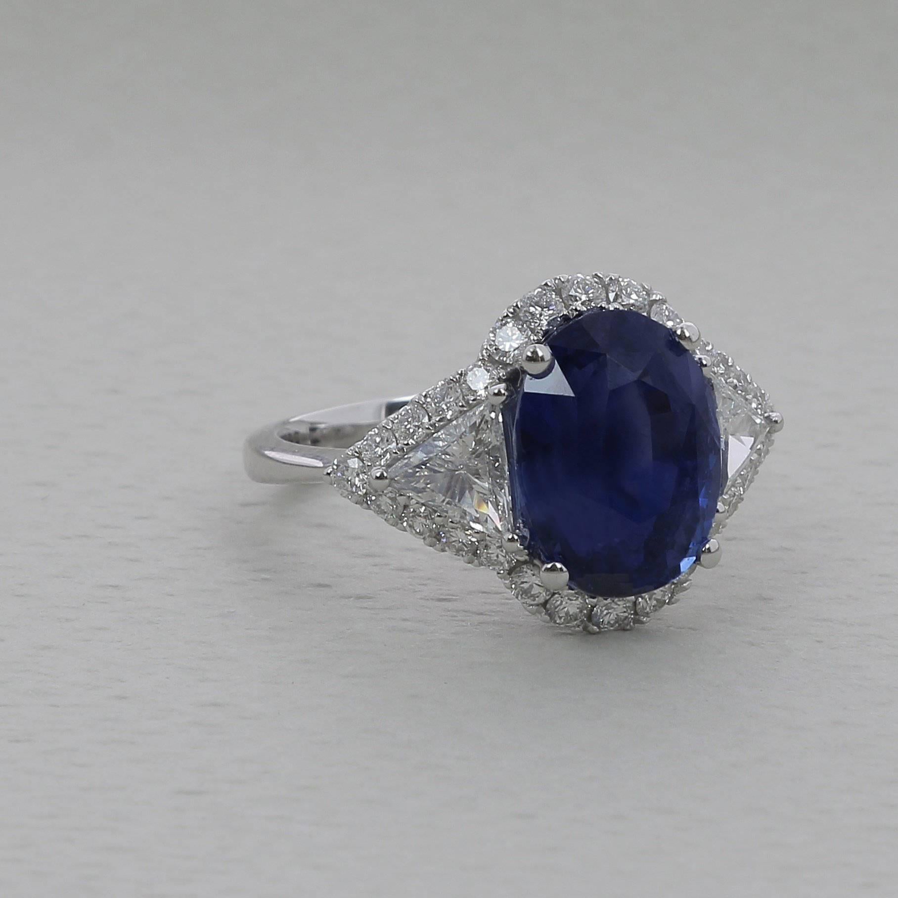 A Vivid Blue Sapphire Ring weighing 6.97 carats. 
The stone’s shape is oval, having for colors a striking Vivid Blue. 
The ring is with two Troidia Diamond weighing 0.67 Carats and 28 Round Diamonds weighing 0.64 Carats. 
The Sapphire is accompanied