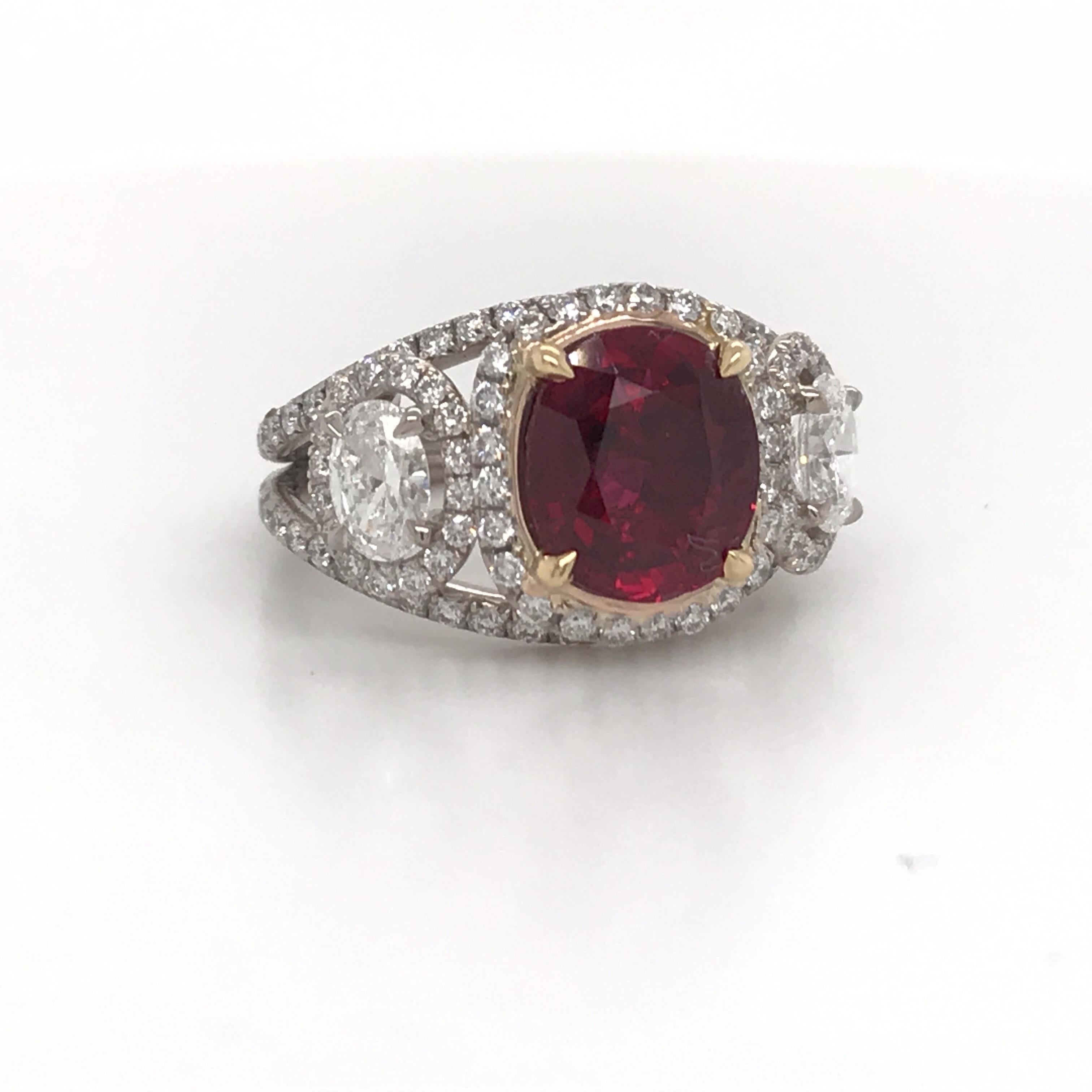 GRS Certified ring featuring one oval shape natural Ruby weighing 2.57 carats flanked with two diamond ovals and numerous round brilliants. 
Ruby:
Dimension: 8.84 x 7.80 x 3.89 mm
Color: Vivid Red Pigeon Blood
No Heat

Please email for more rubies. 