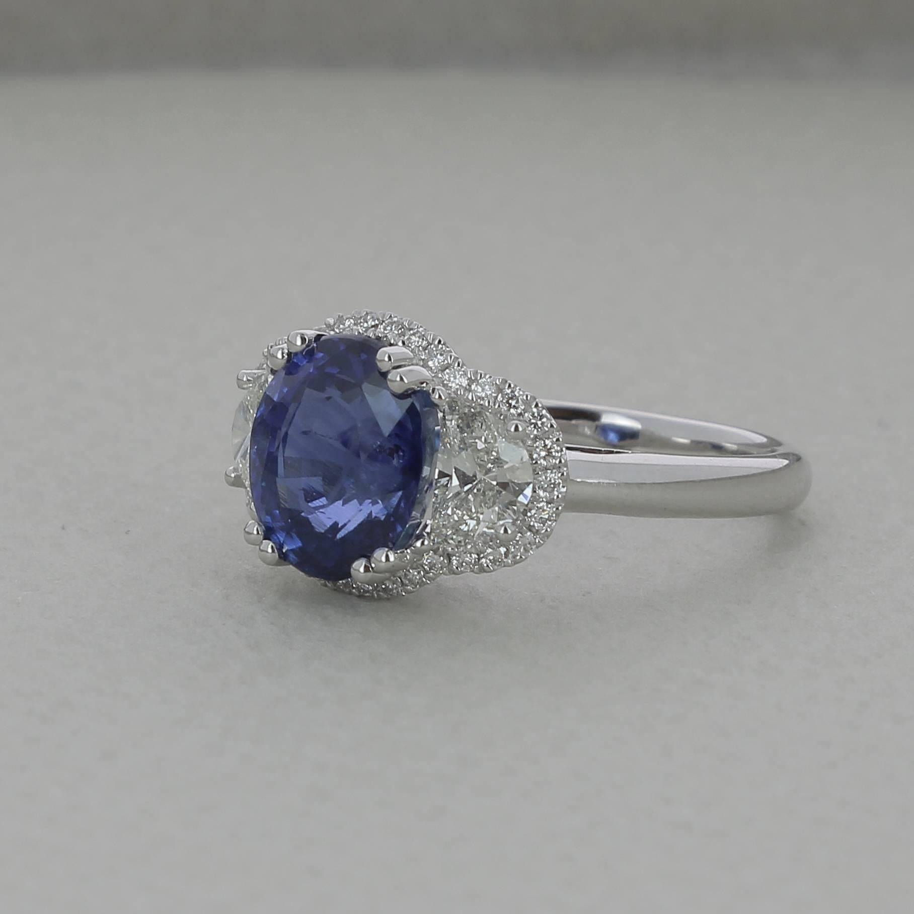 An amazing Oval Royal Blue Blue Sapphire Ring, flanked on each side by a single Half-Moon Diamonds weighing 0.76 Carats and surround with Round Diamond.
The total weight of the Sapphire is 4.55 Carats, the Gemstone is certified as a Vivid Blue