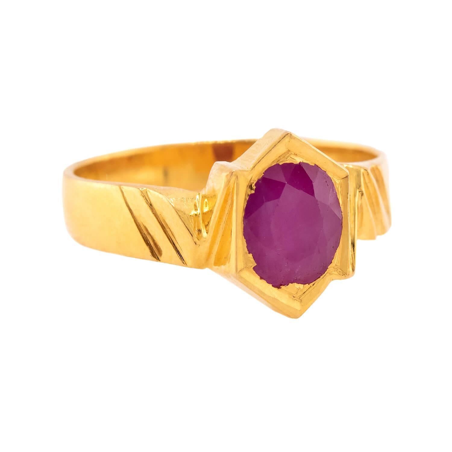 Une magnifique bague en rubis du bijoutier GRT Jewell ! Réalisée en or jaune 22k, cette bague est ornée d'un rubis ovale à facettes. La pierre sertie sur la lunette présente une teinte rouge rosé vibrante, qui contraste merveilleusement avec la