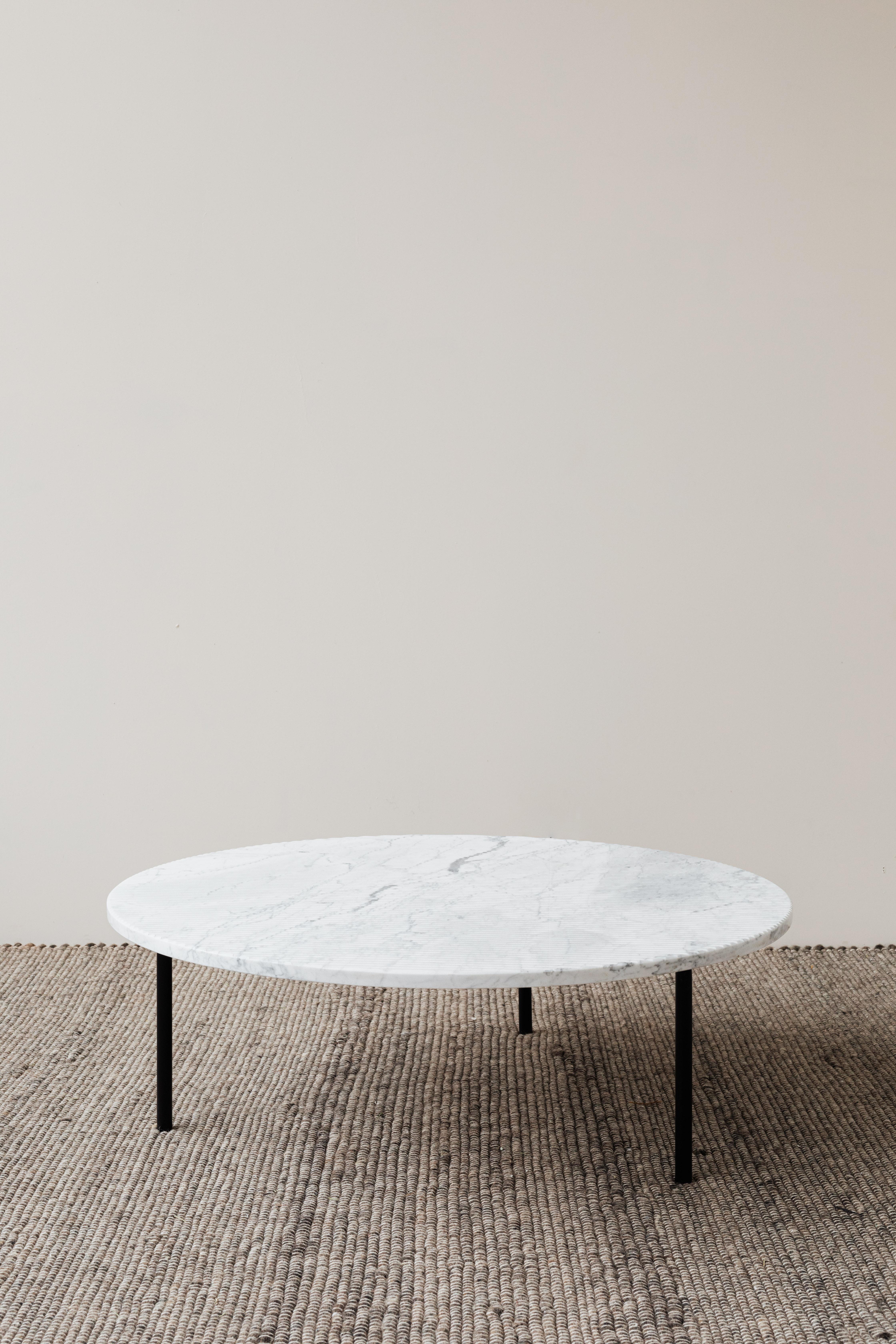 Gruff L Carrara Coffee Table by Un’common
Designed by Małgorzata Korycka.
Dimensions: Ø 90 x H 30 cm.
Materials: Carrara marble.

Available in different stone and finish options: Carrara, grooved Carrara, grooved Pietra Gray, and brushed Nero
