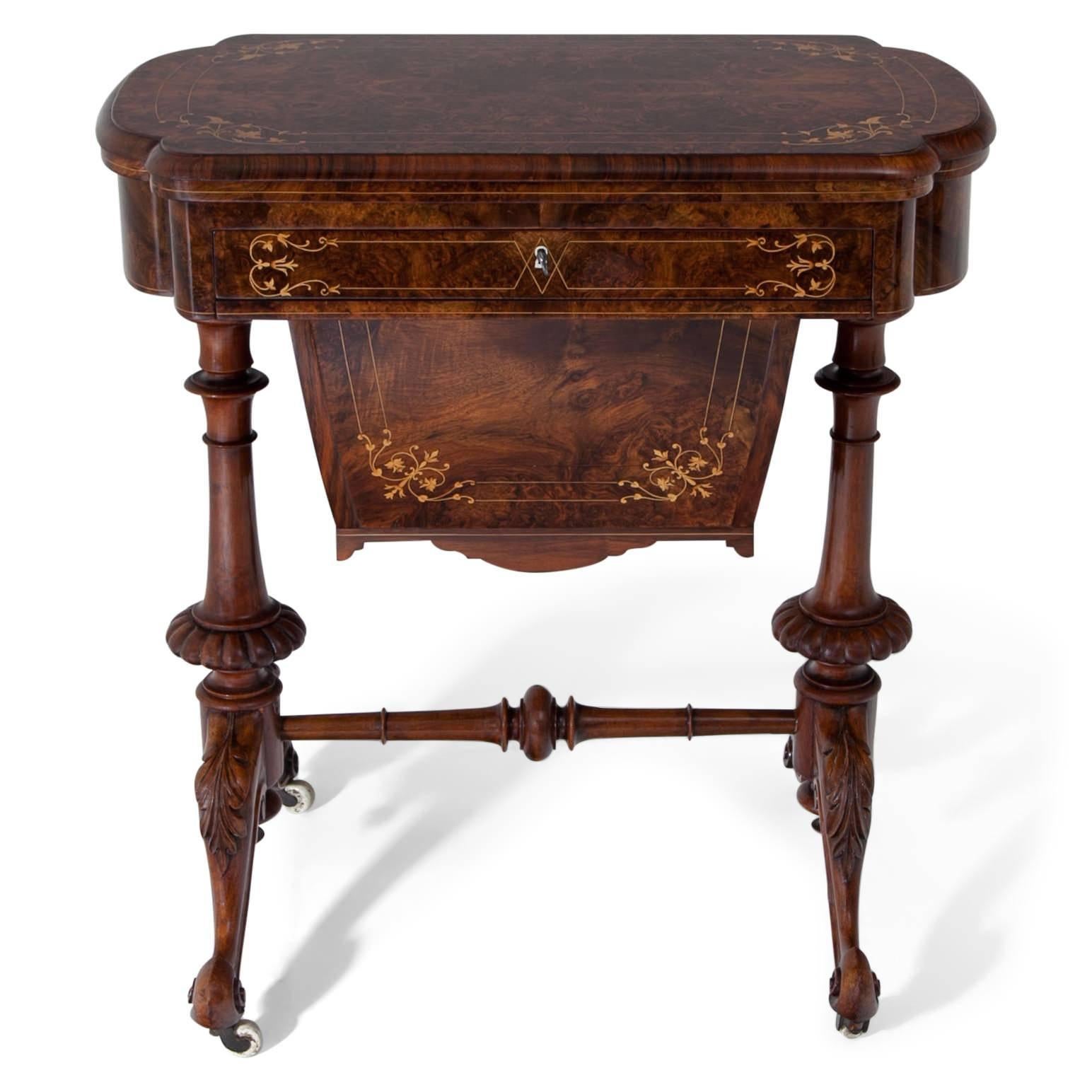 Walnut-veneered game table on wheels with volute-shaped feet and baluster legs with a turned stretcher in-between. The top is foldable and reveals an inlayed chess and backgammon board. The drawers offer space for game pieces and playing cards. The