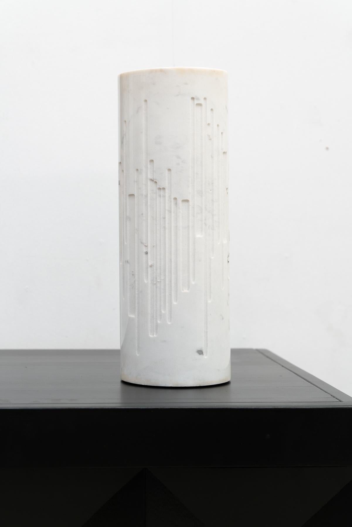 Lampe de table cylindrique en marbre du Grupo NP2, fabriquée en Italie. Cette lampe présente un design tubulaire évidé et gravé en marbre de Calacatta, permettant à la lumière de transparaître gracieusement.

N'hésitez pas à nous contacter pour