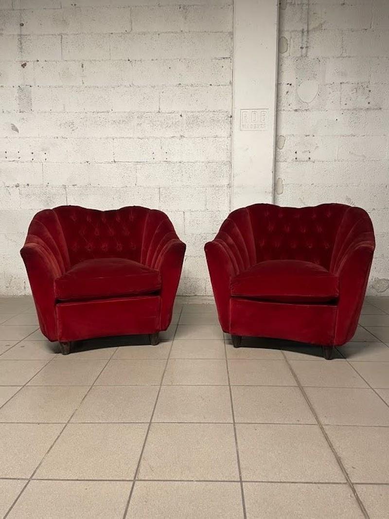 Group consisting of 2 pairs of 1950s armchairs with capitonné backs and wooden cone feet.

The filling is sprung and the cushions are feather.

The still original upholstery is red velvet.

They are in good overall condition but a reupholstery and