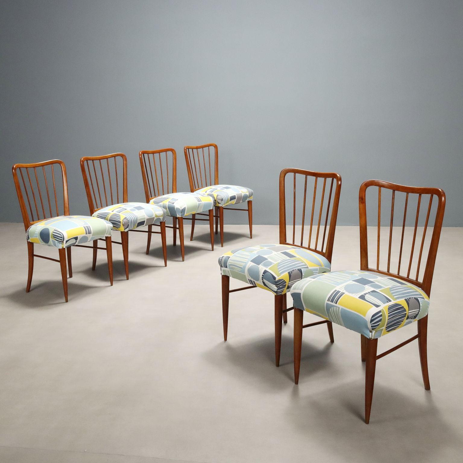 Ensemble de six chaises de salle à manger avec structure en bois de hêtre, assise à ressort et revêtement à motifs dans les tons bleu, jaune, vert et bleu.
