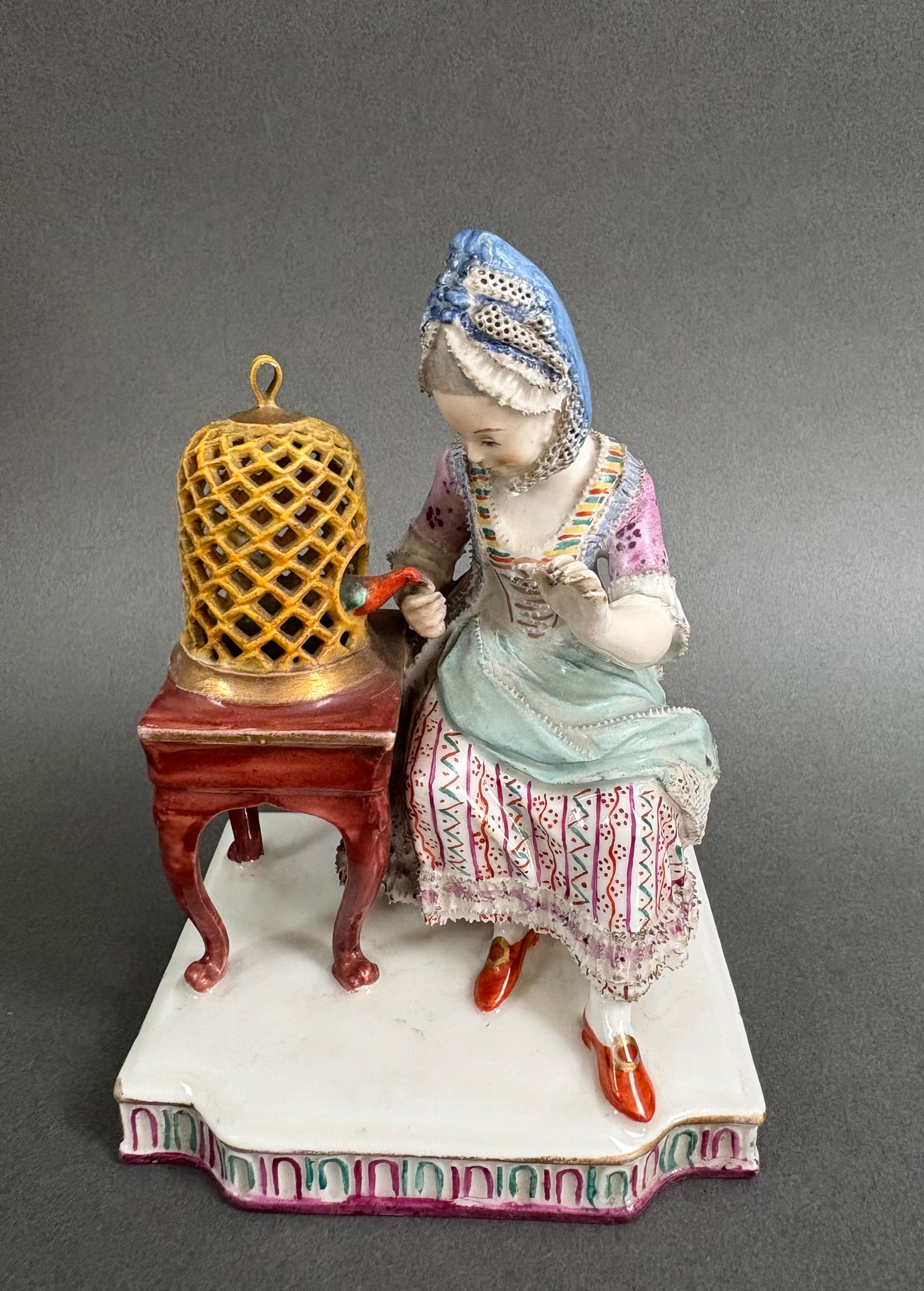 Grupo de porcelana policromada que representa a una joven abriendo una jaula de pájaros.  Fabricación alemana del siglo XIX. El grupo se basa en un modelo de 1772 de Johann Carl Schönheit para la manufactura de Meissen. Perfecto estado. Nunca