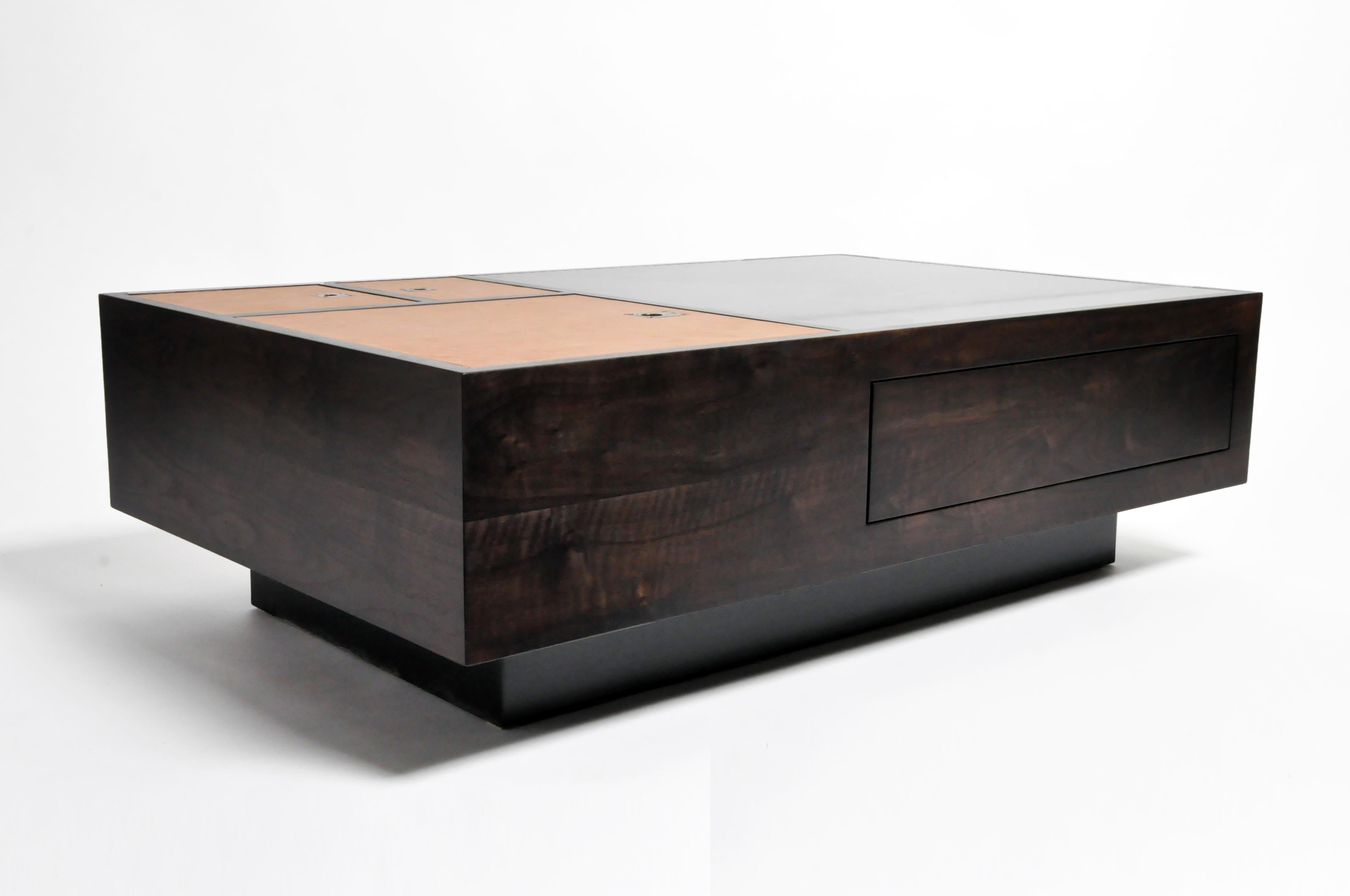 Introducing the GTR4 Flex Table by The Golden Triangle. Inspired by British campaign furniture, it’s made to go anywhere. It has a solid Walnut frame and a leather and steel top. Surface doors with flush mount fittings lift up to reveal deep storage