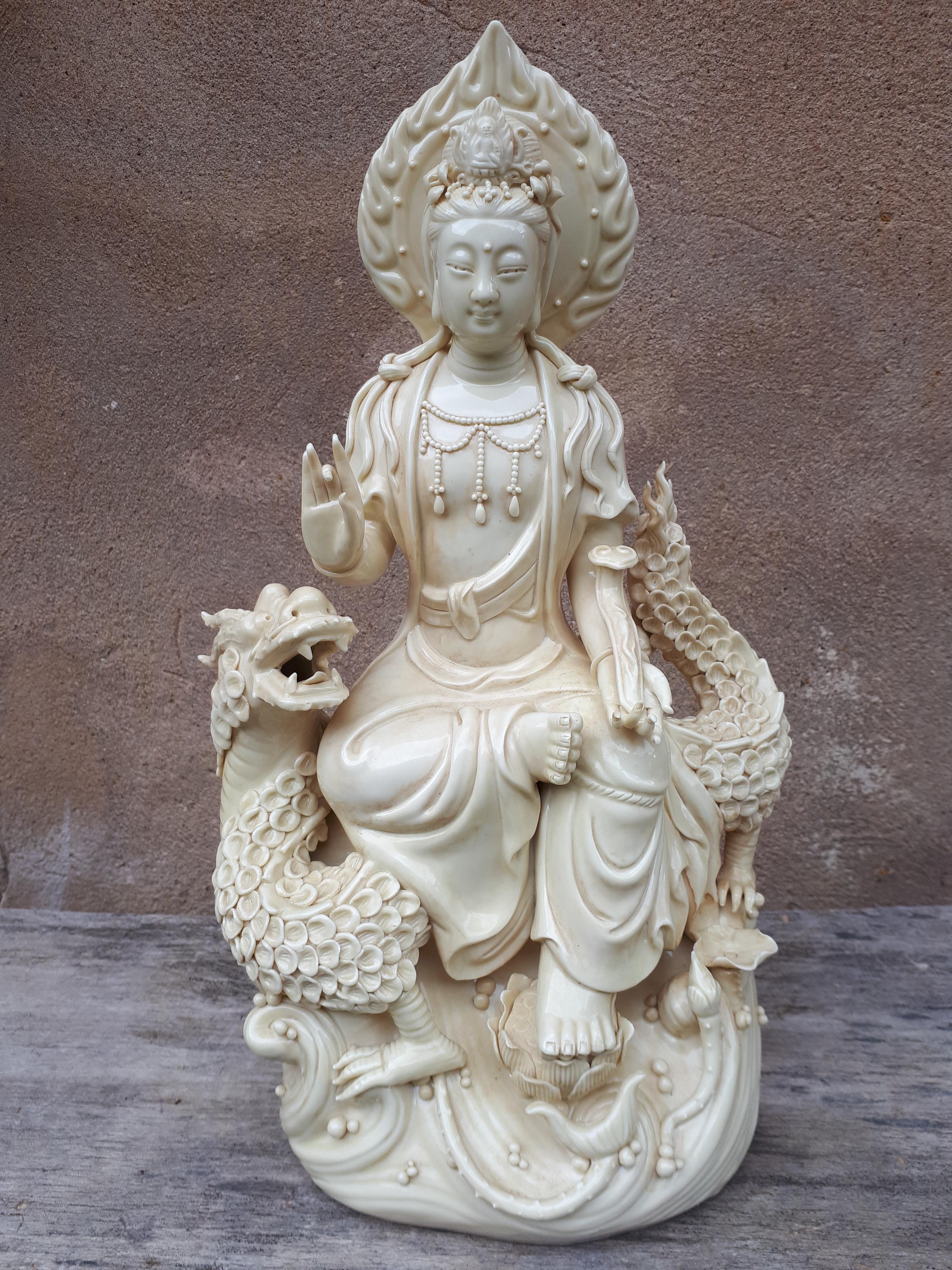 Porzellanstatue von Guanyin, dargestellt in einer königlichen Liegeposition auf einem Drachen, der ein Zepter in der linken Hand hält.
Die auf die linke Hand geklebten Finger beeinträchtigen die Ästhetik des Ganzen nicht und sind zudem in einer