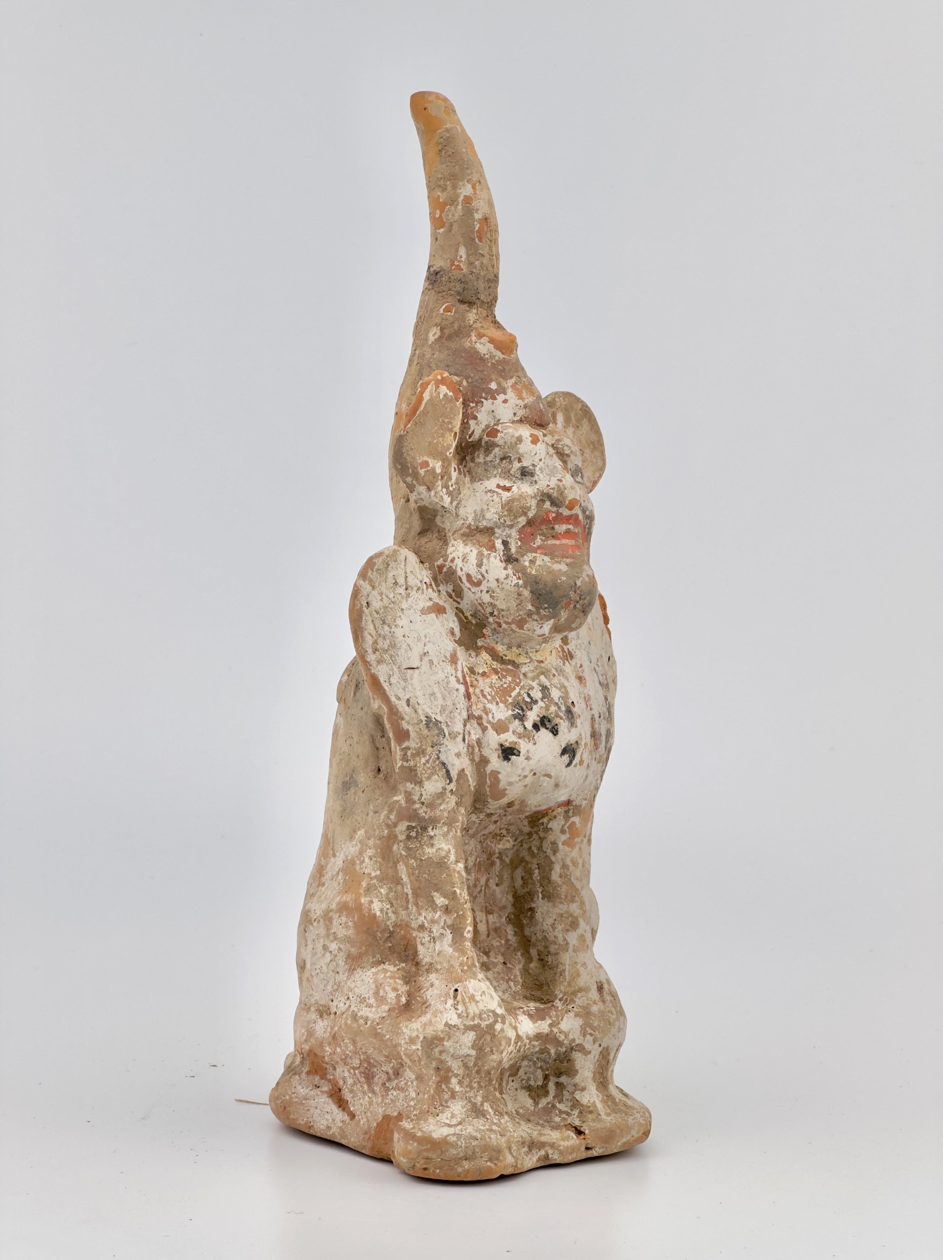 This figure appears to be a terracotta statuette, possibly representing a court official or a deity given the distinct headgear which could signify a rank or divine attribute. The style of the figurine, with its facial features and remnants of